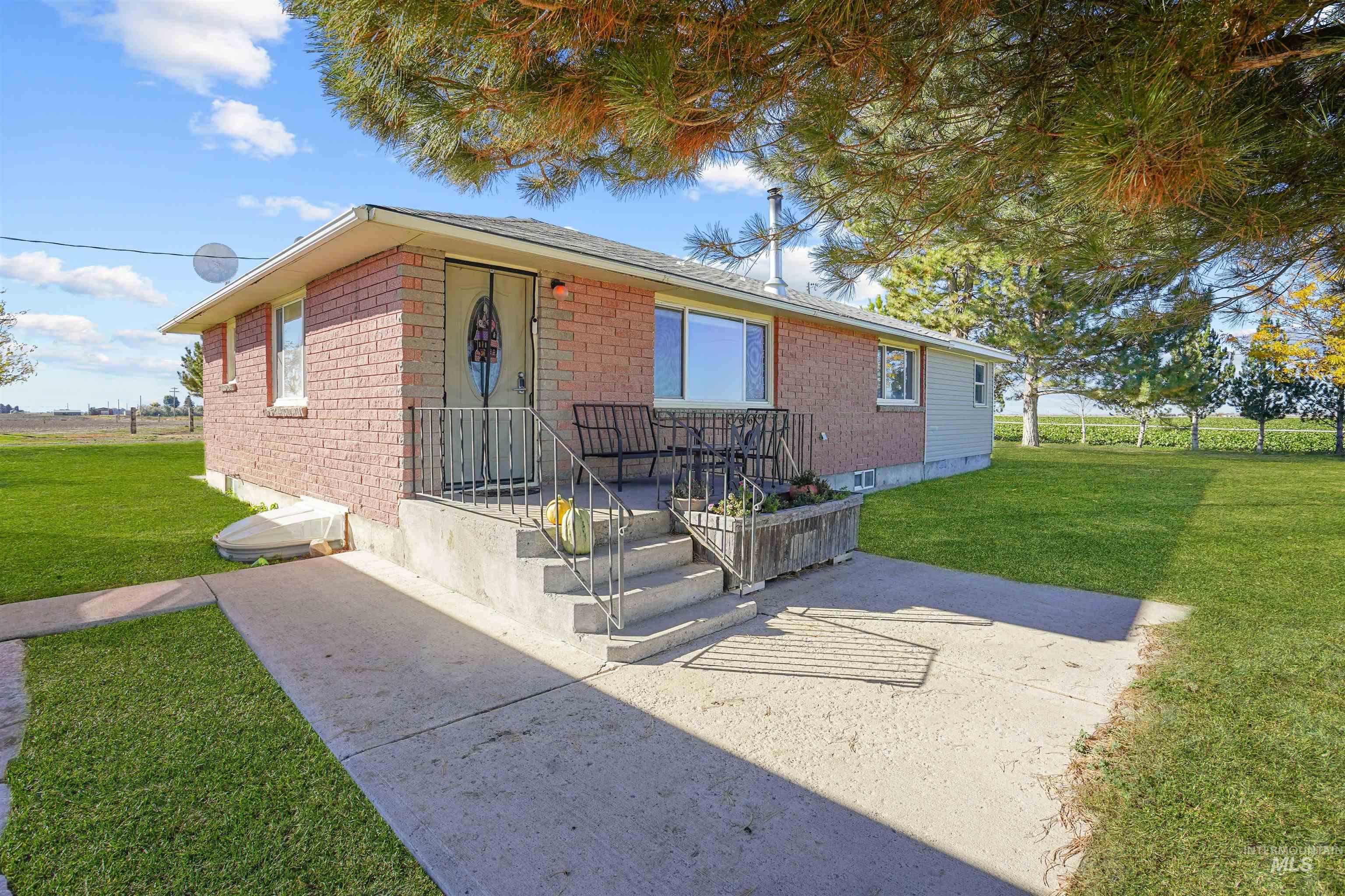 View of front facade featuring a front yard, brick siding, and a patio area