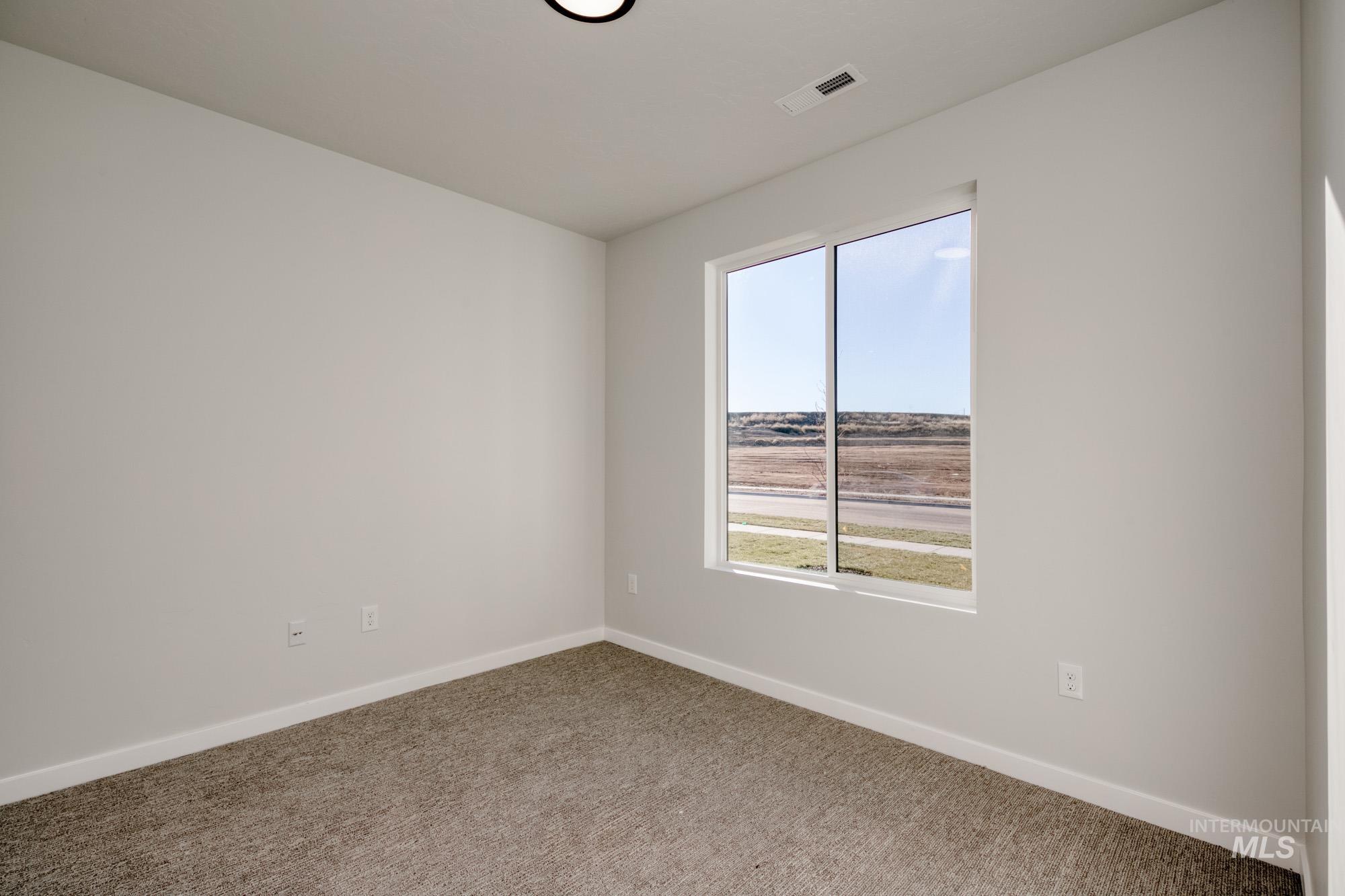 Empty room featuring baseboards and carpet flooring
