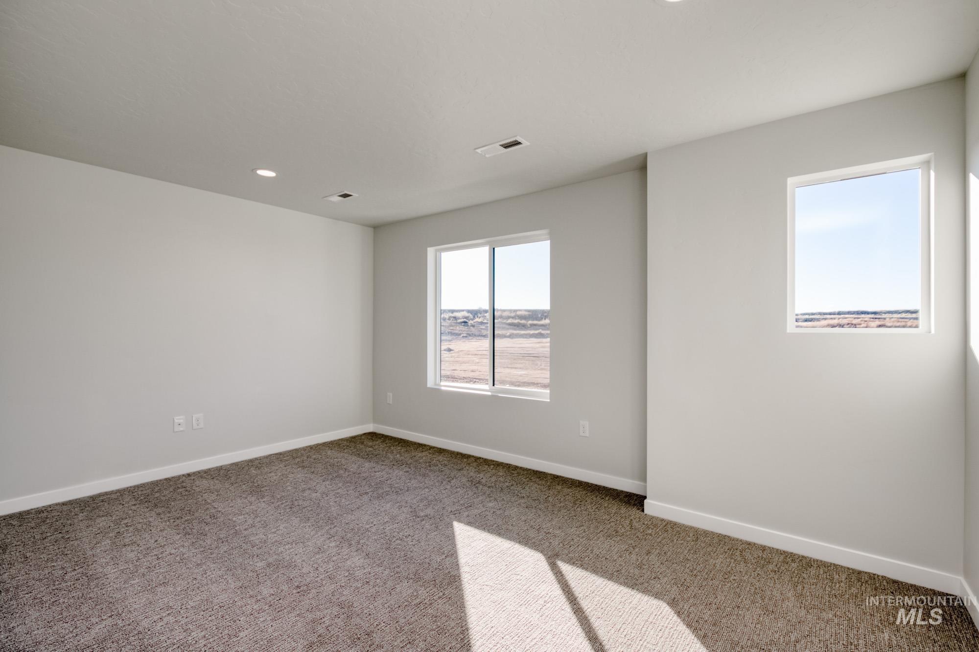 Carpeted empty room featuring baseboards and recessed lighting