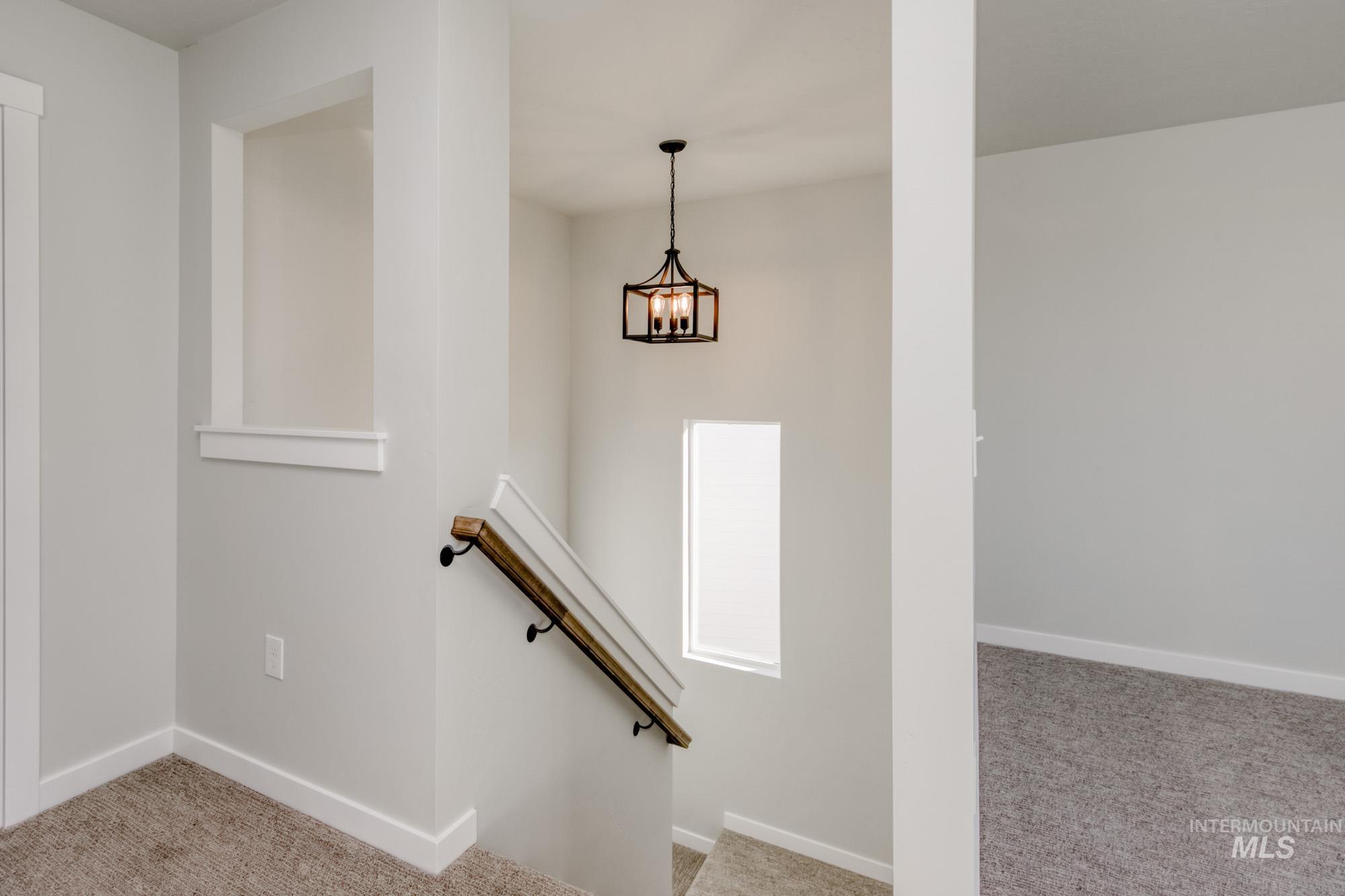 Stairway featuring carpet floors and a chandelier