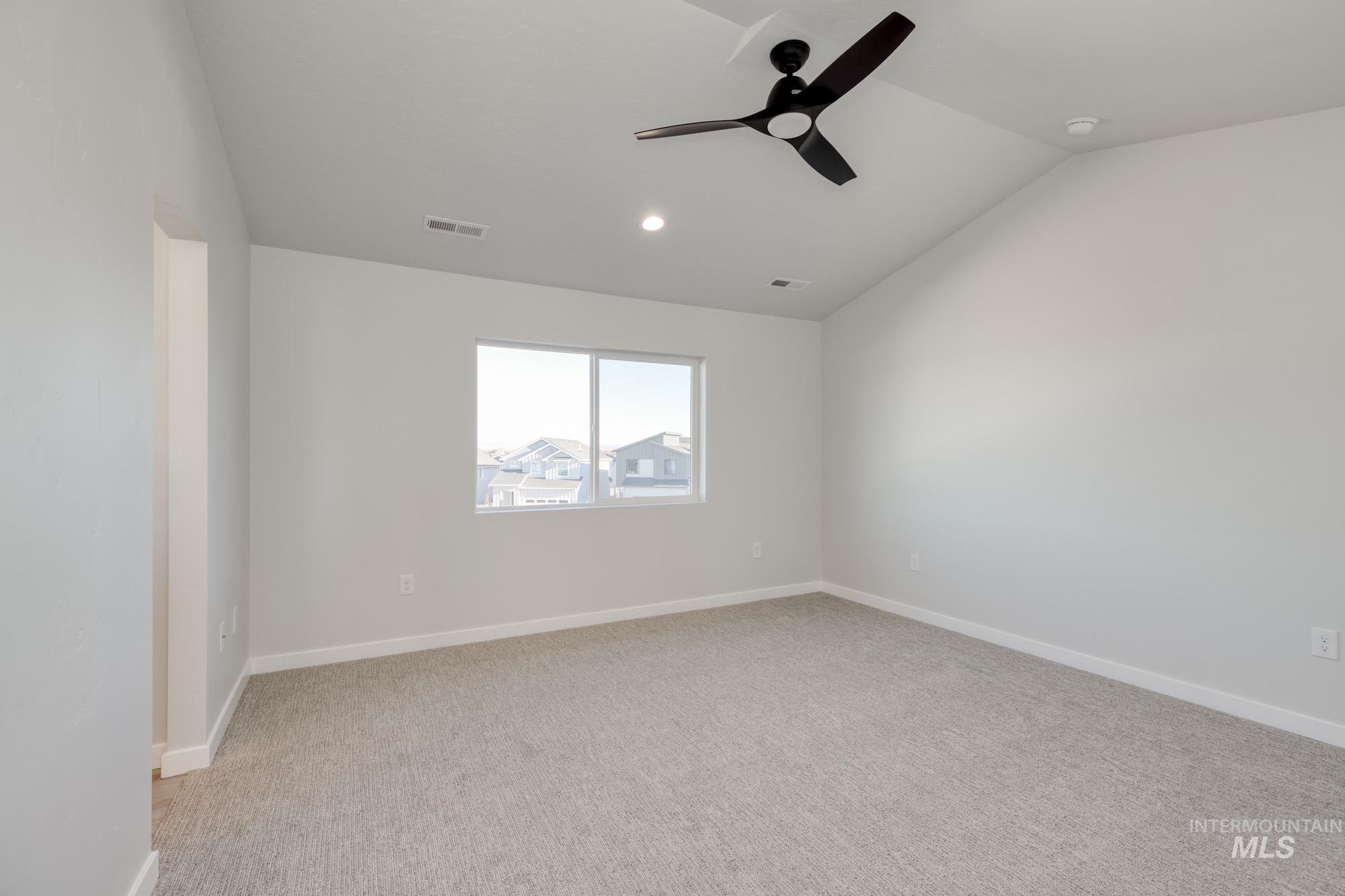 Spare room featuring lofted ceiling, light colored carpet, a ceiling fan, and recessed lighting