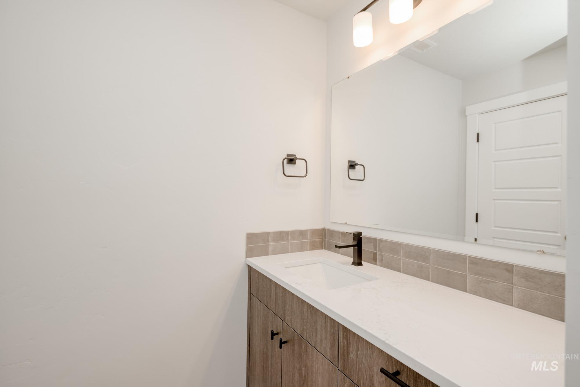 Bathroom featuring vanity and backsplash