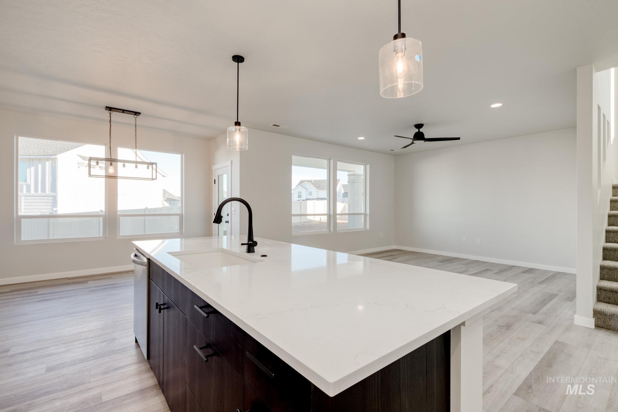Kitchen featuring hanging light fixtures, dark brown cabinetry, light wood-style flooring, and recessed lighting