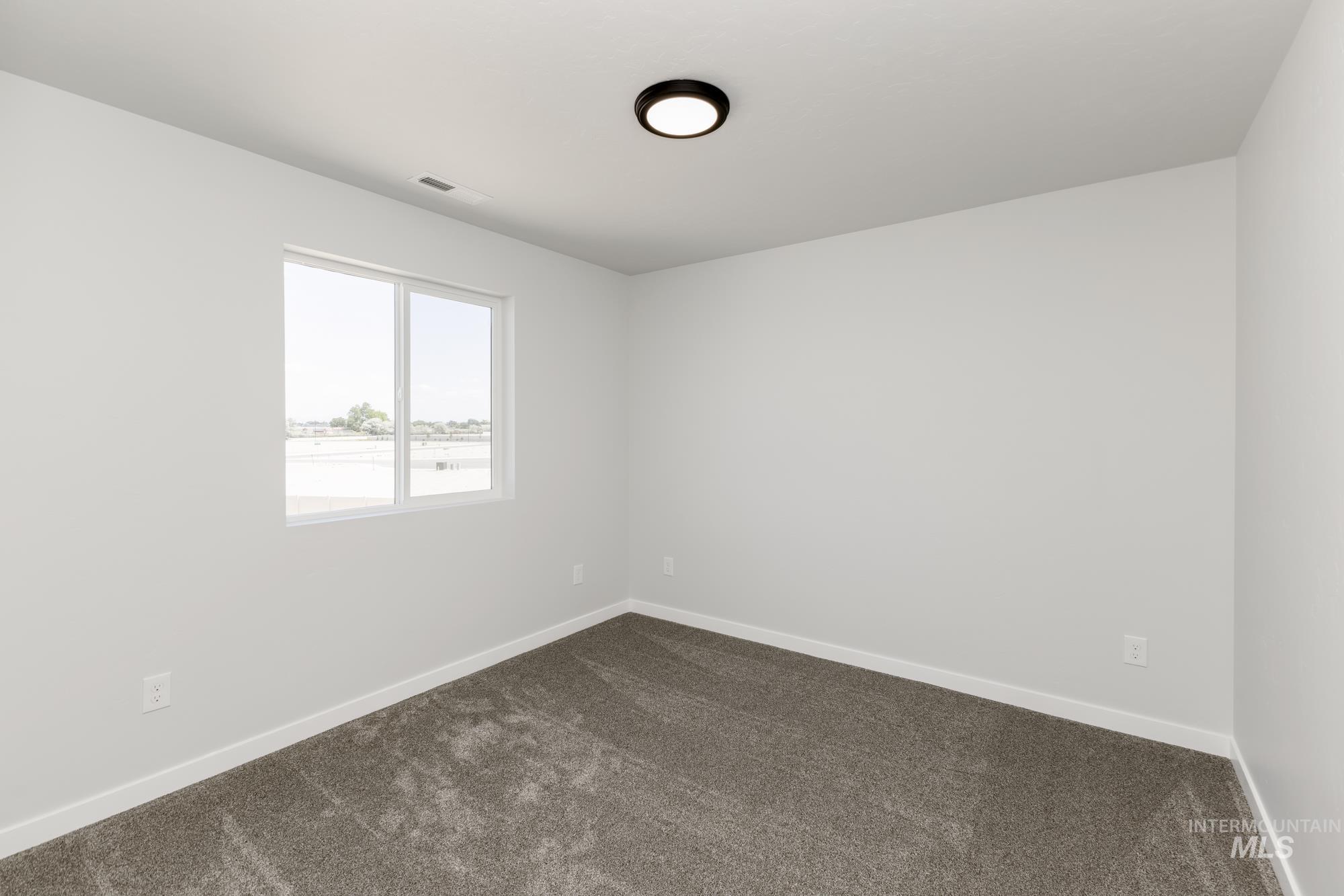 Empty room with dark carpet and baseboards