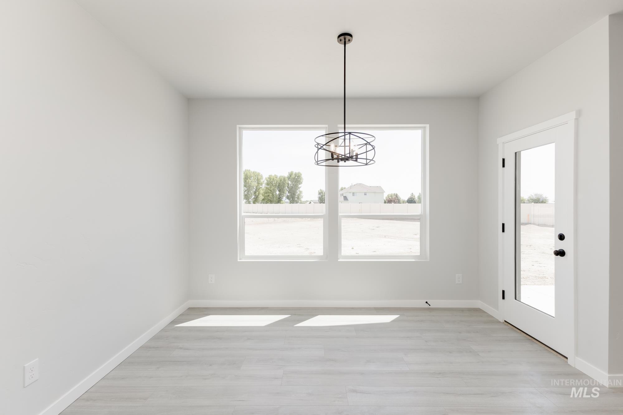 Unfurnished dining area with light wood finished floors and a chandelier