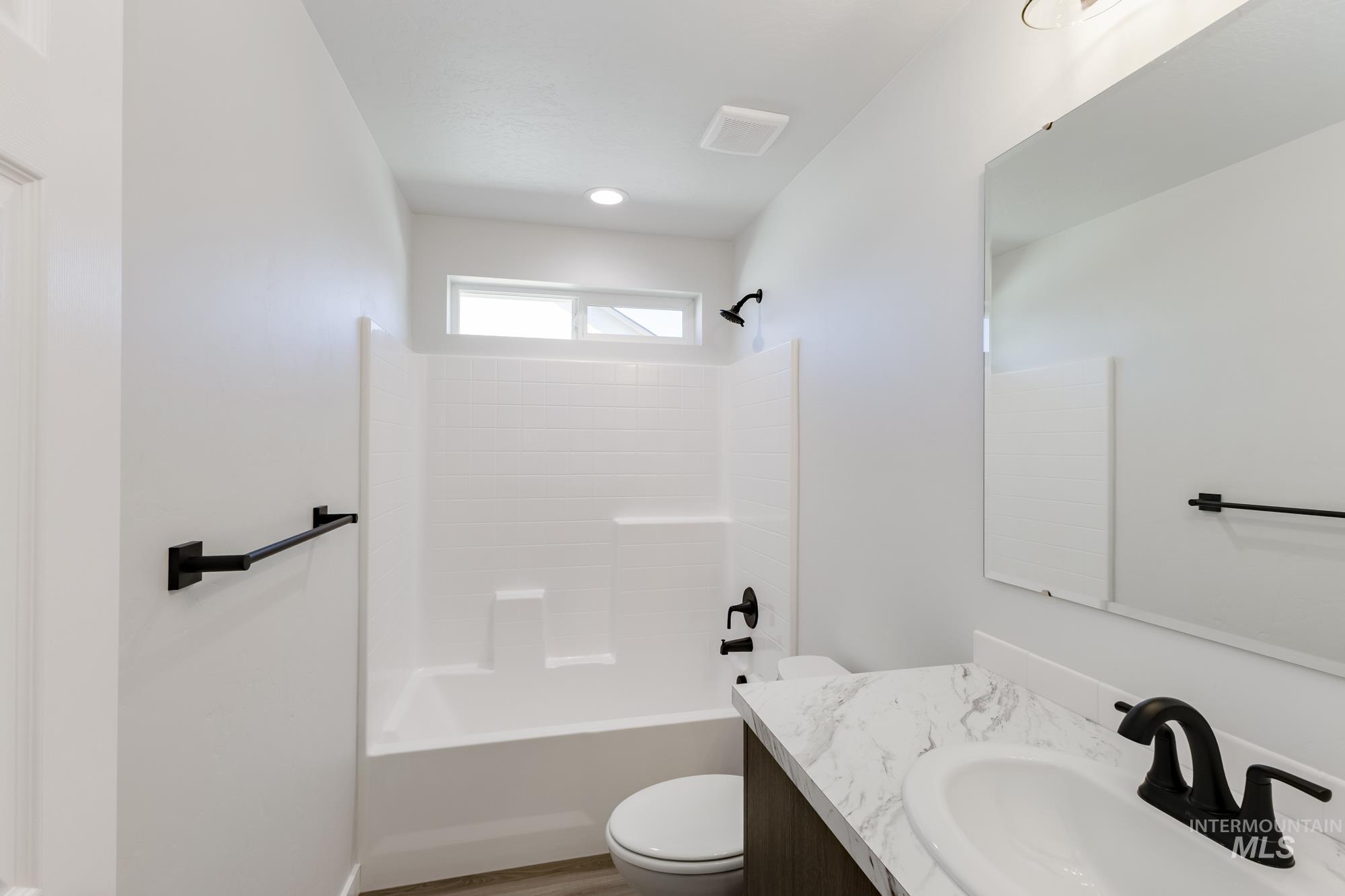 Bathroom featuring vanity, bathtub / shower combination, and light wood finished floors