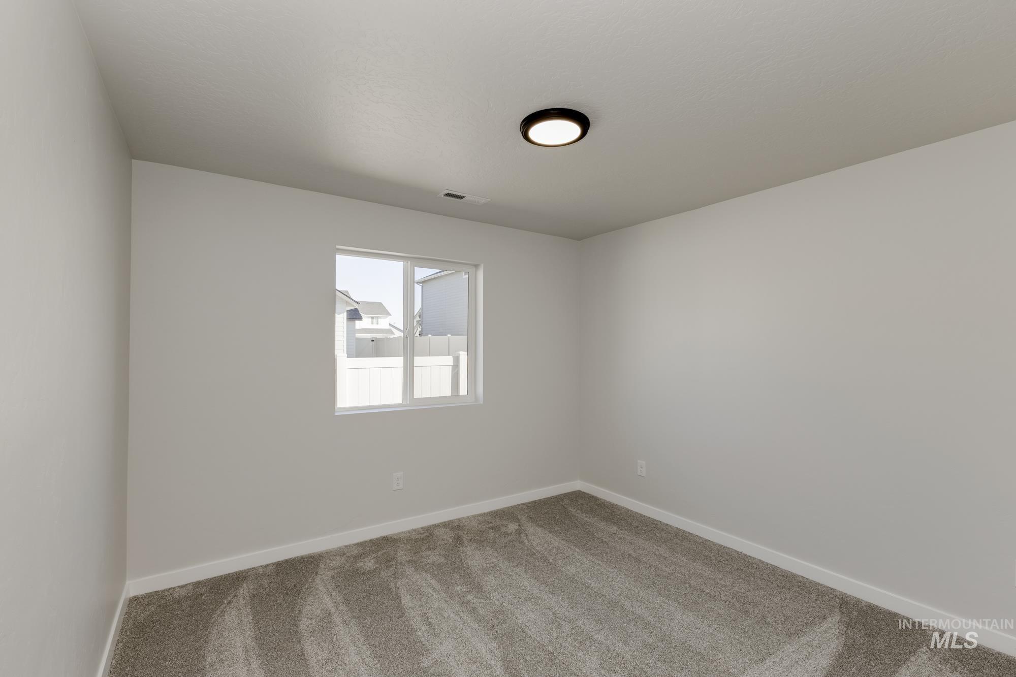 Carpeted empty room featuring baseboards