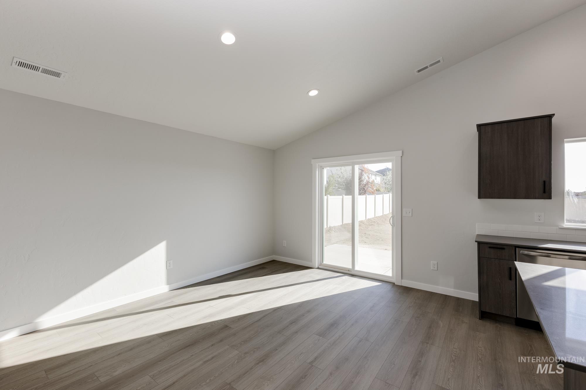 Unfurnished dining area featuring recessed lighting, light wood-style flooring, and lofted ceiling