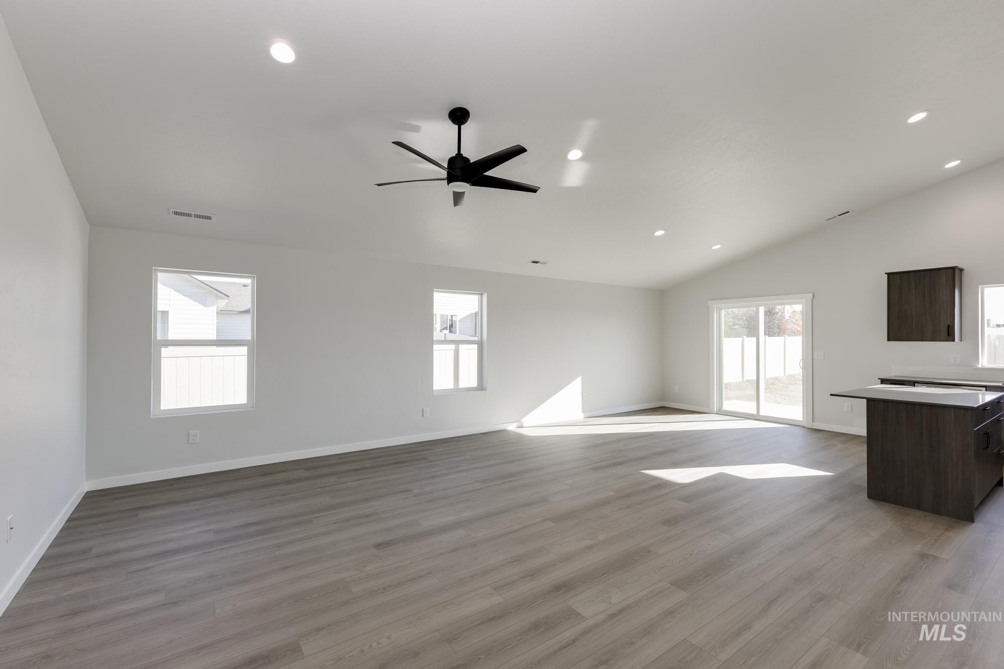 Unfurnished living room featuring light wood-type flooring, recessed lighting, vaulted ceiling, and ceiling fan