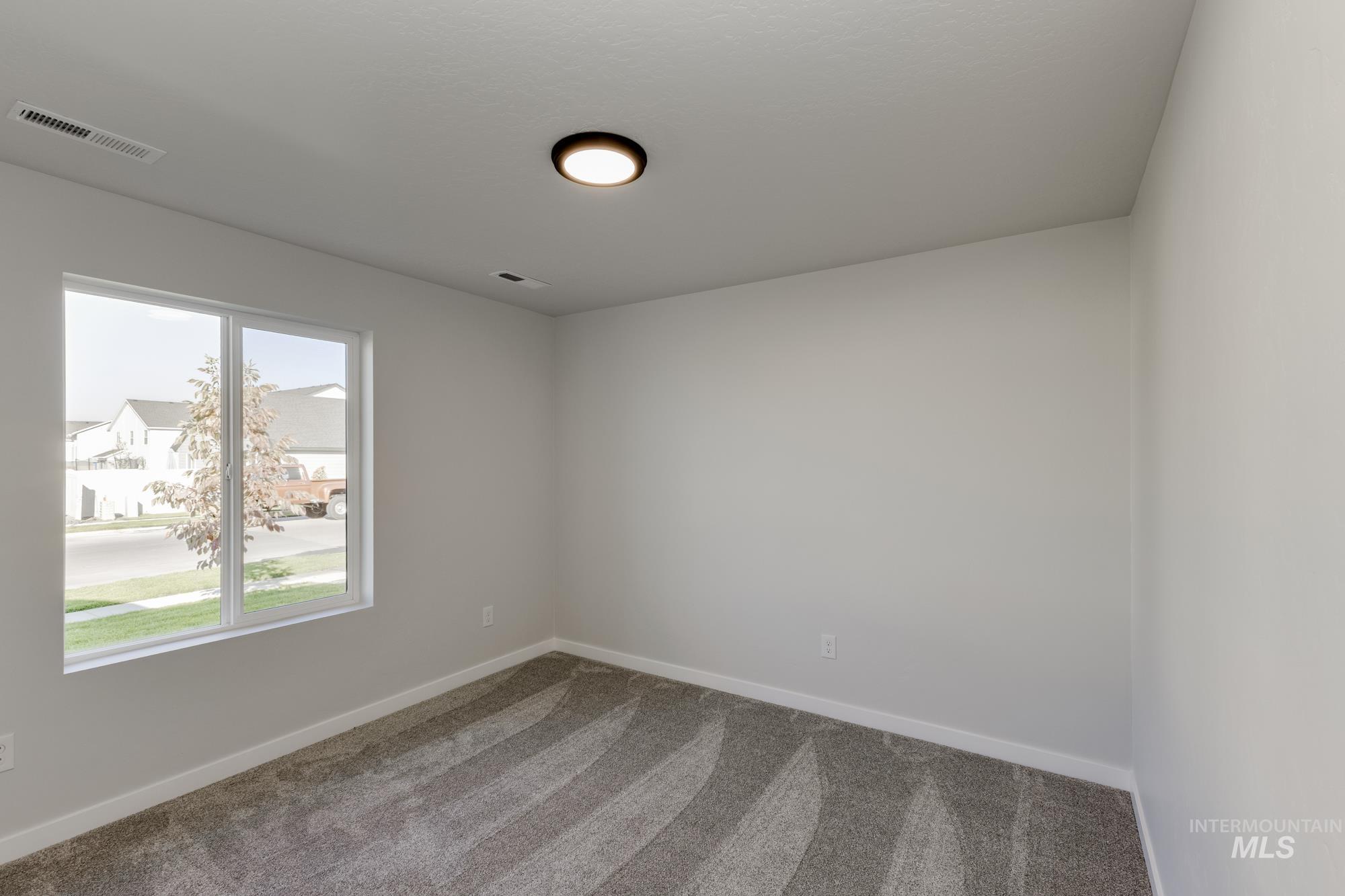 Carpeted empty room featuring baseboards