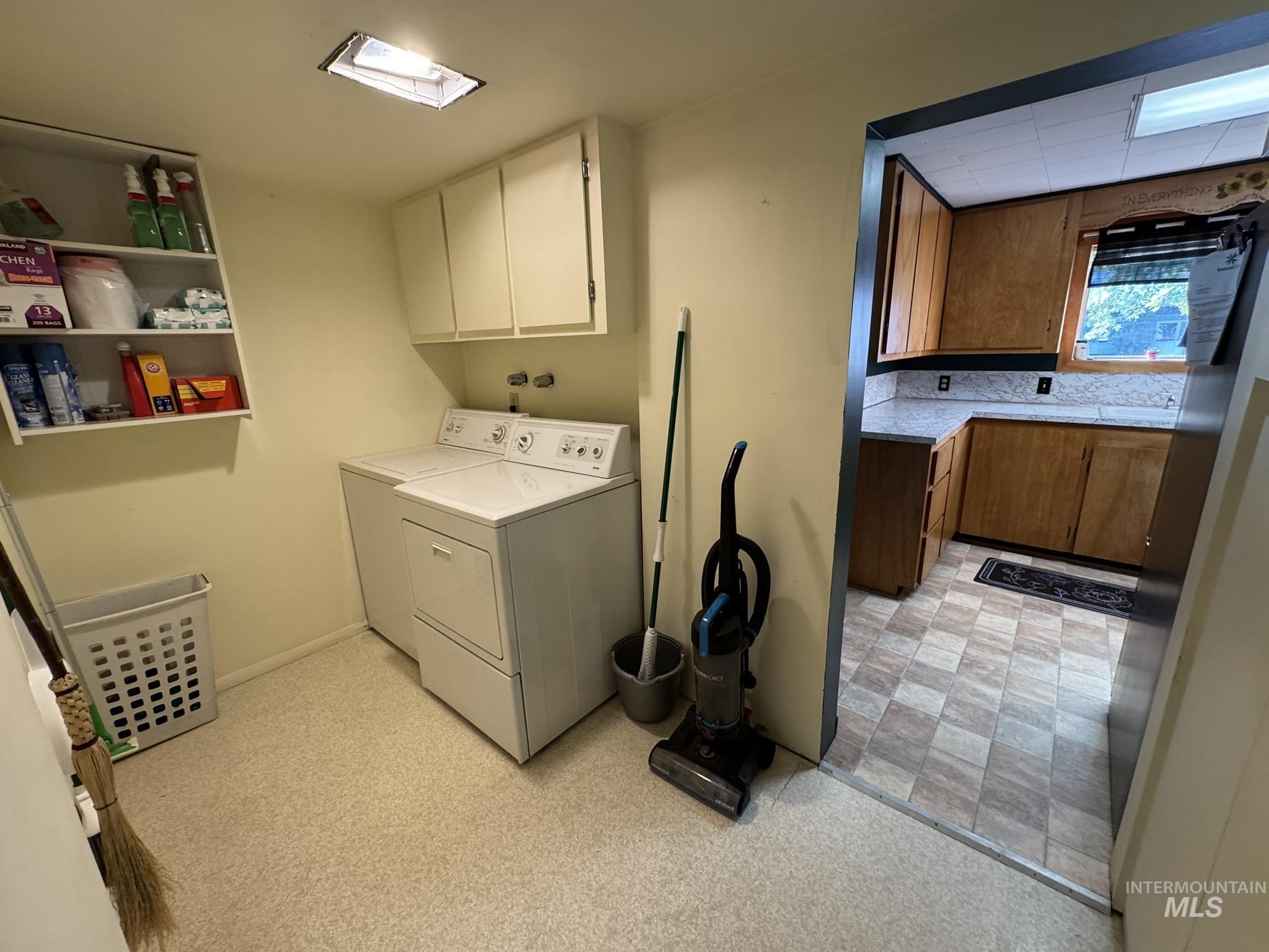 Laundry room with independent washer and dryer and baseboards