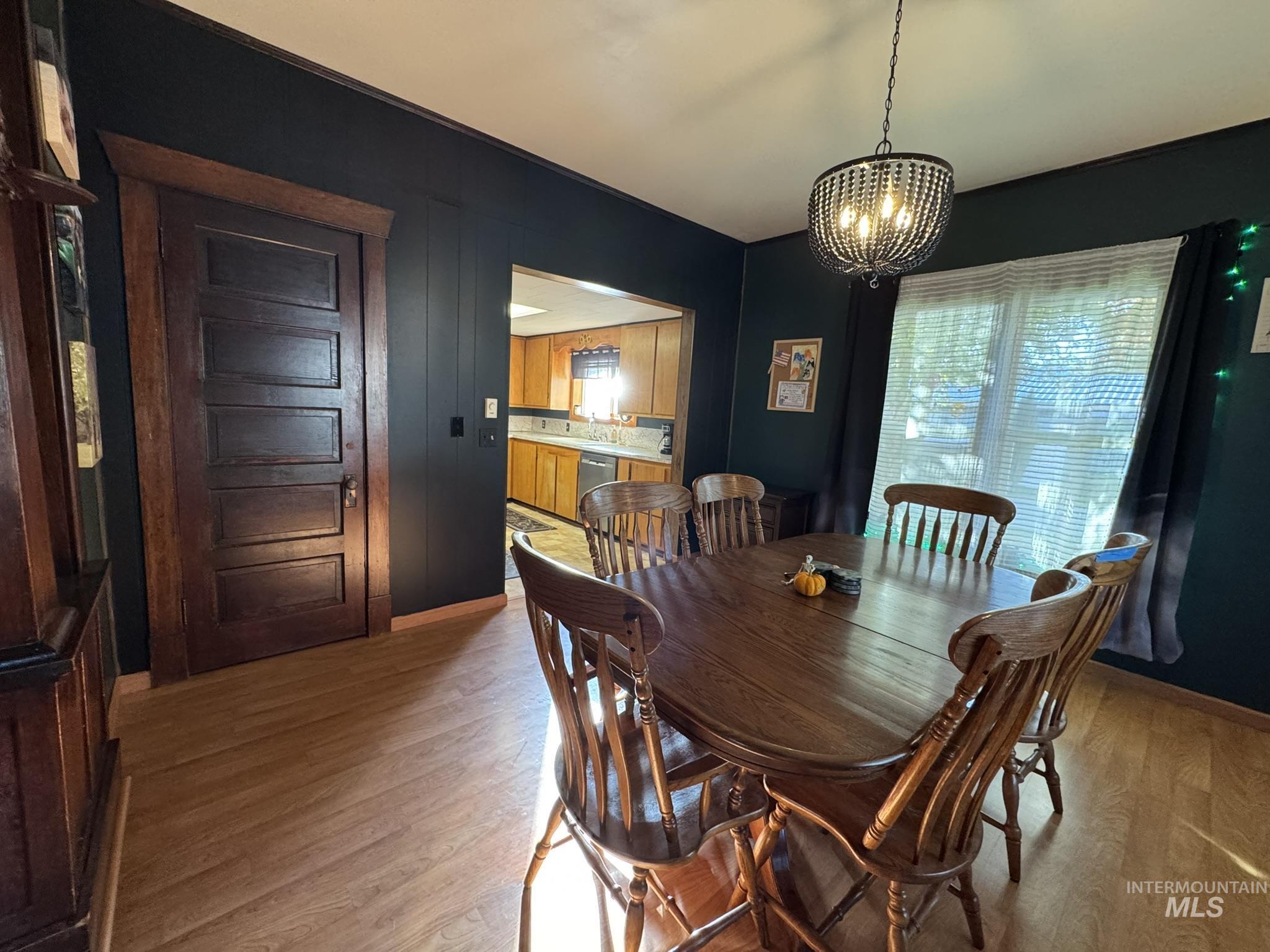 Dining space with light wood finished floors and a chandelier