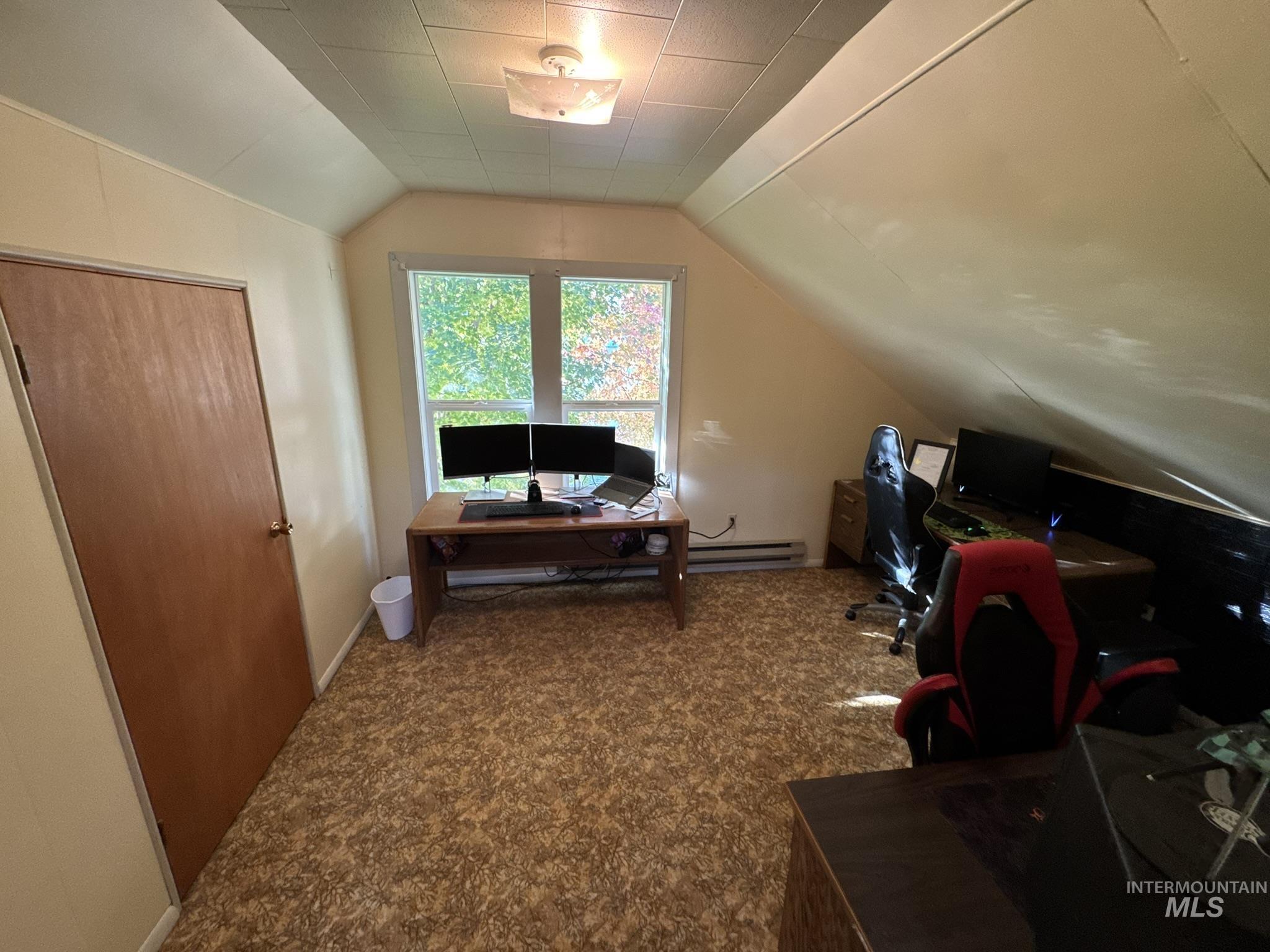 Office space featuring vaulted ceiling