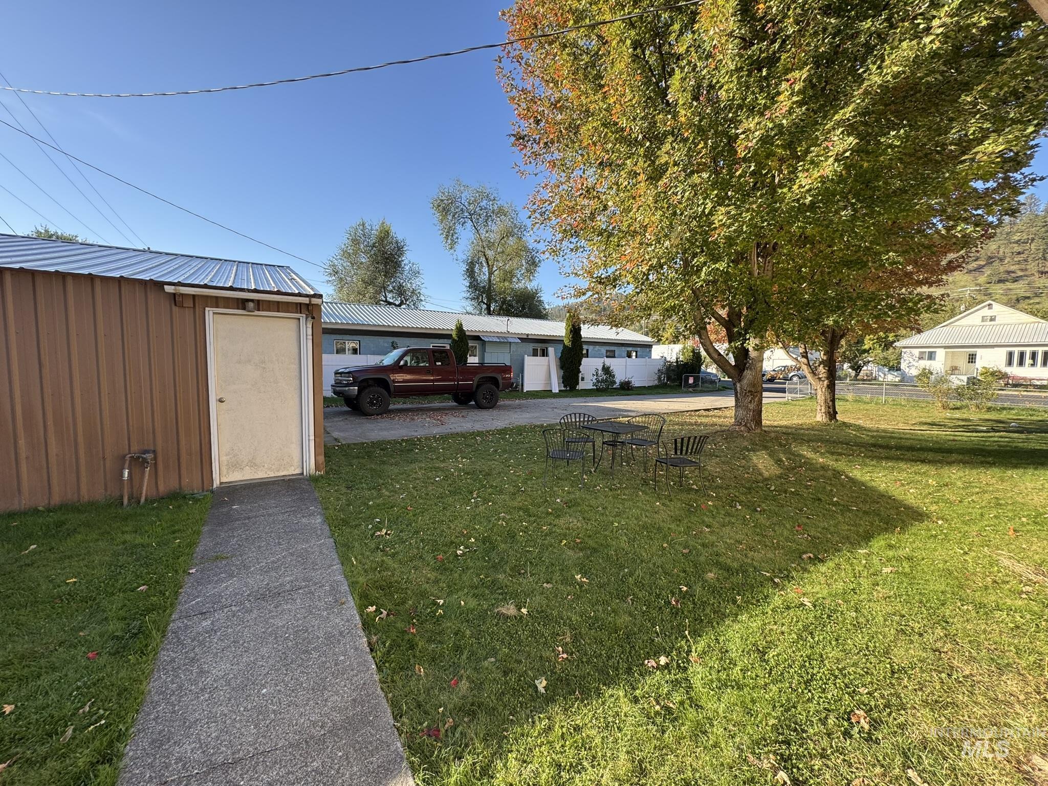 View of grassy yard featuring a storage unit