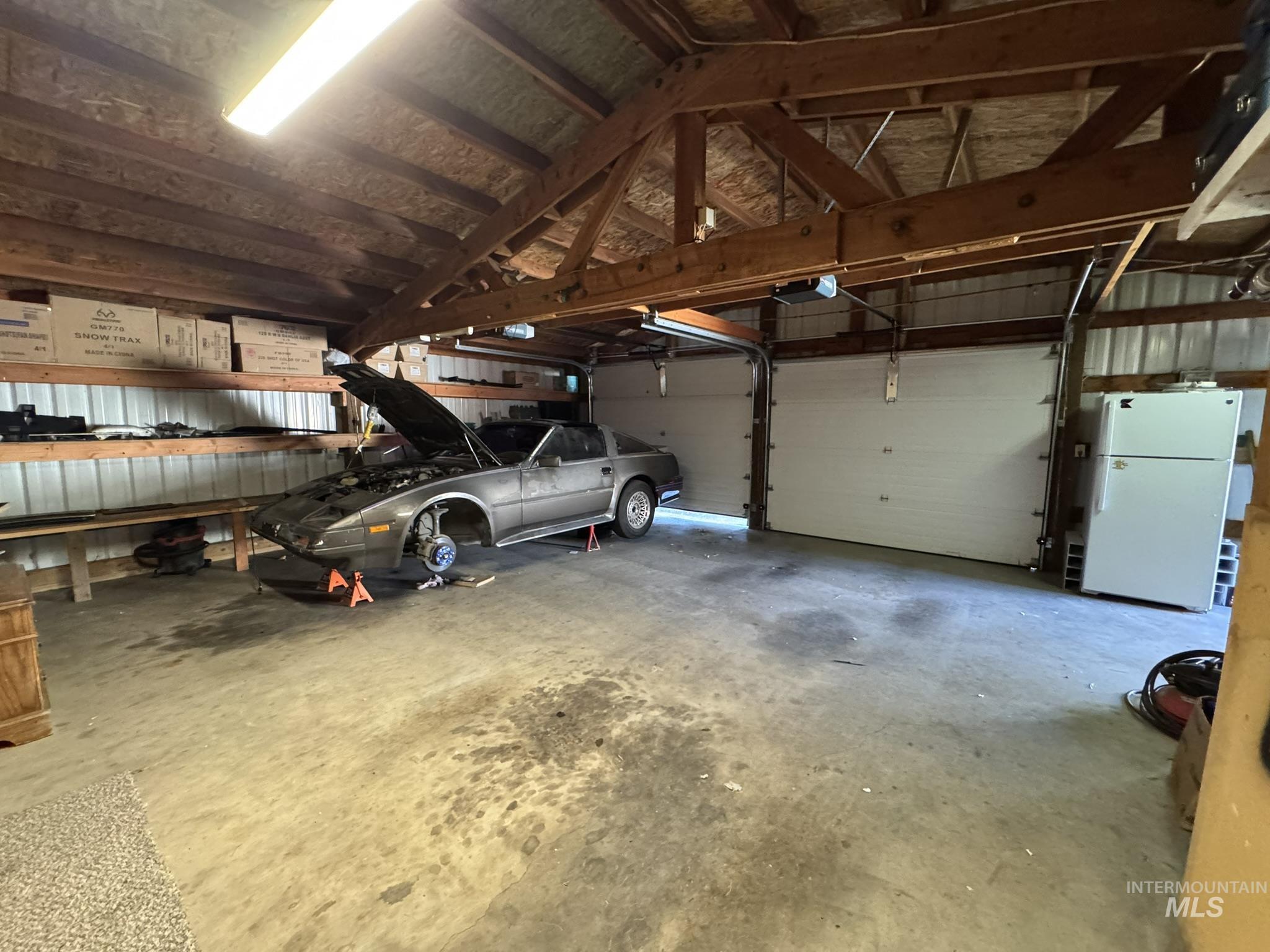 Garage with freestanding refrigerator and a garage door opener