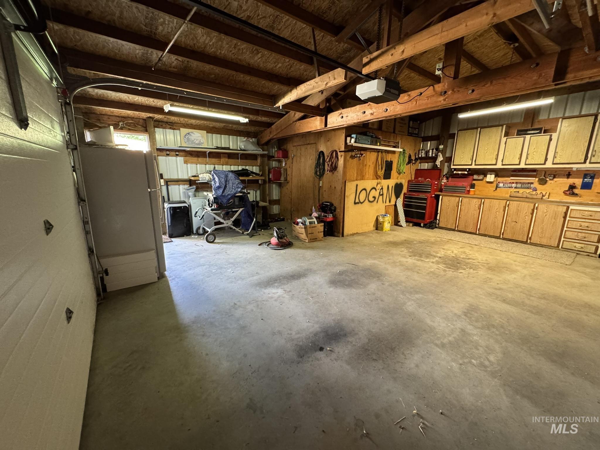 Garage featuring freestanding refrigerator and a garage door opener