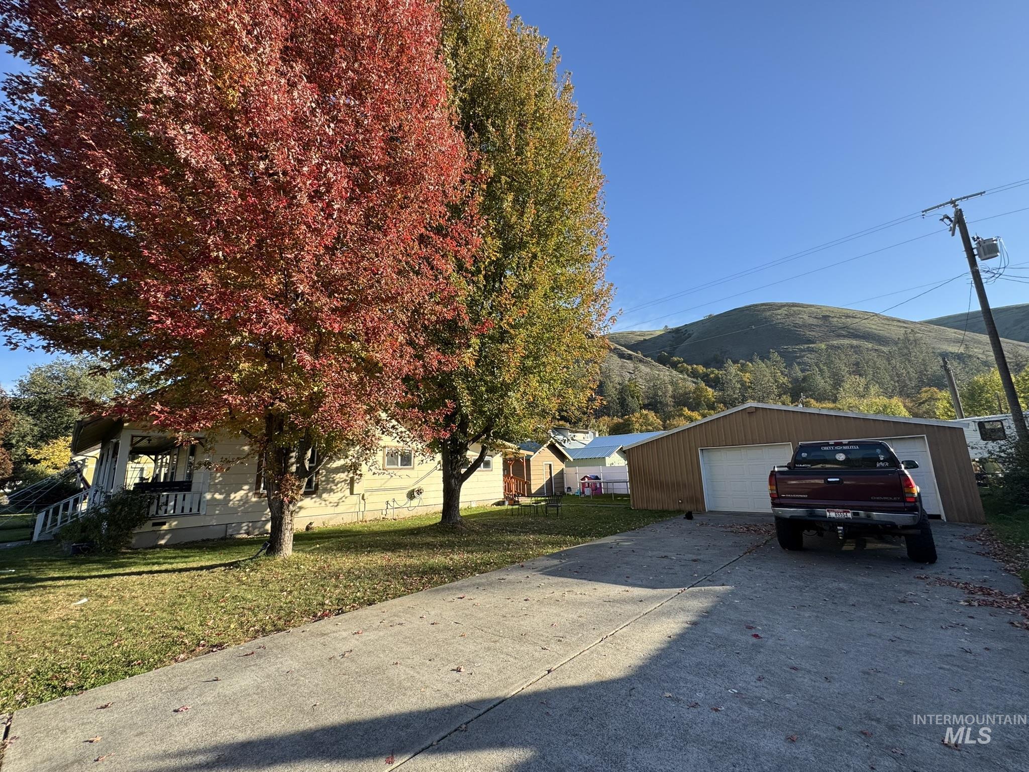 View of front facade with a mountain view, a front lawn, an outdoor structure, and a garage