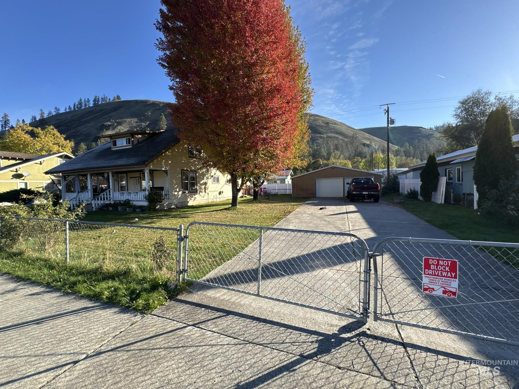 View of front of house featuring a gate, a garage, a porch, a mountain view, and a fenced front yard