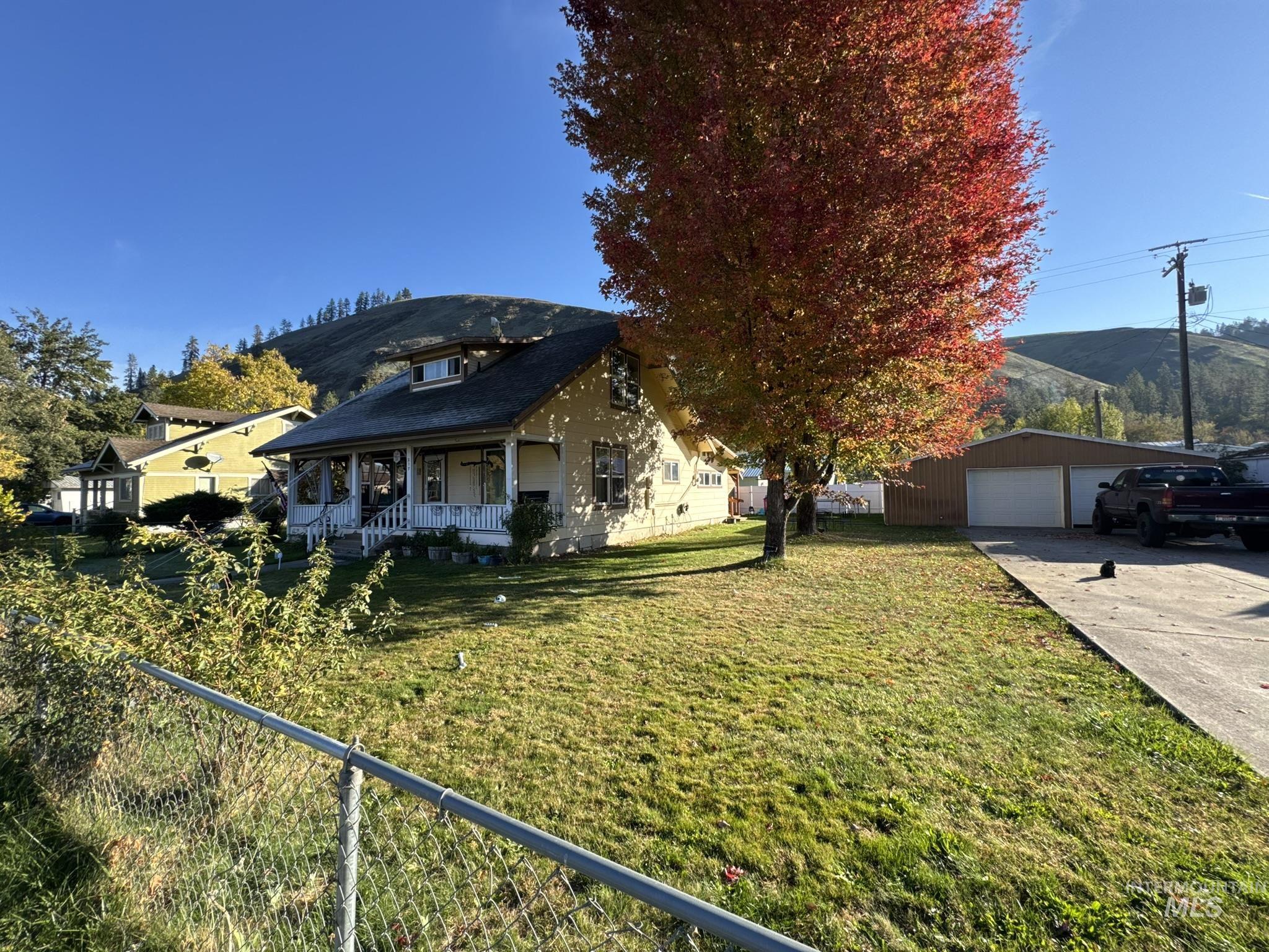 View of front facade featuring a porch, an outbuilding, and a garage