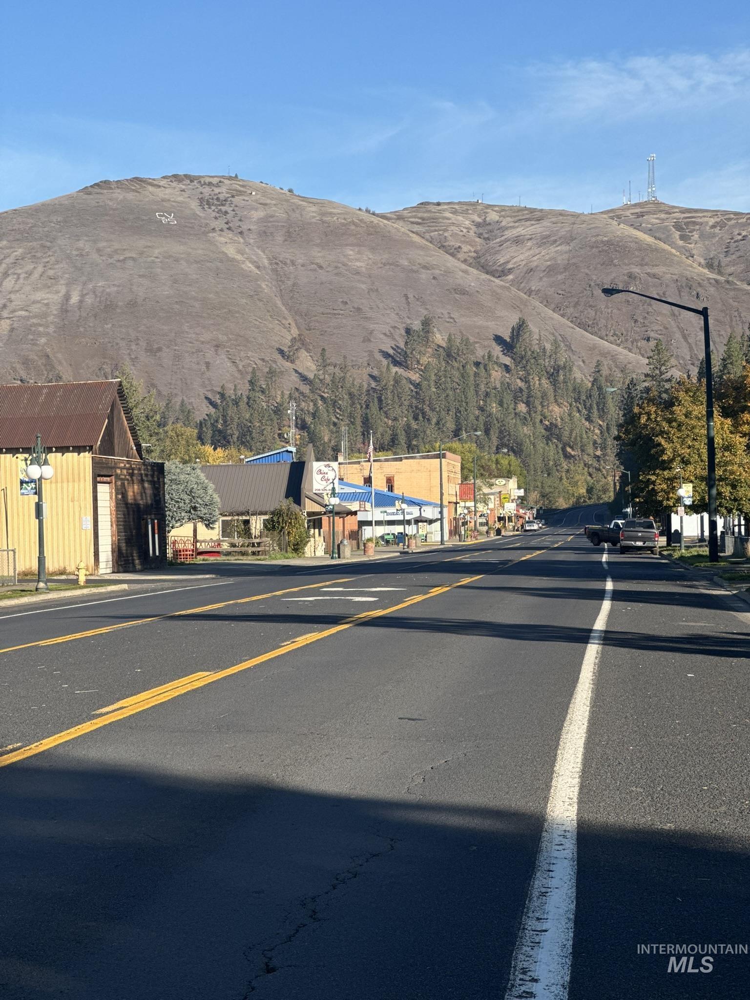 View of asphalt street with a mountain view and street lighting