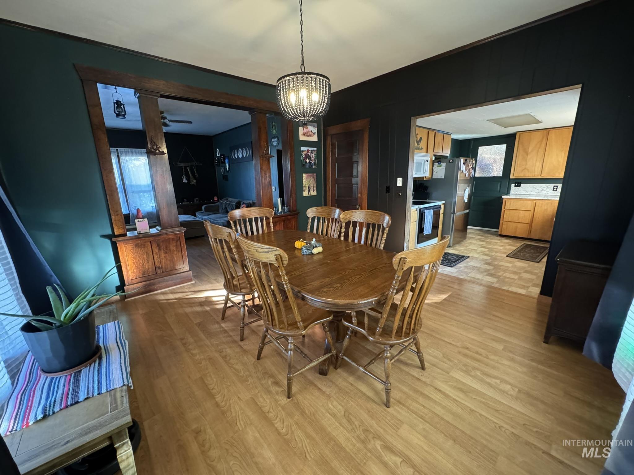 Dining room featuring light wood-type flooring, a chandelier, and a ceiling fan