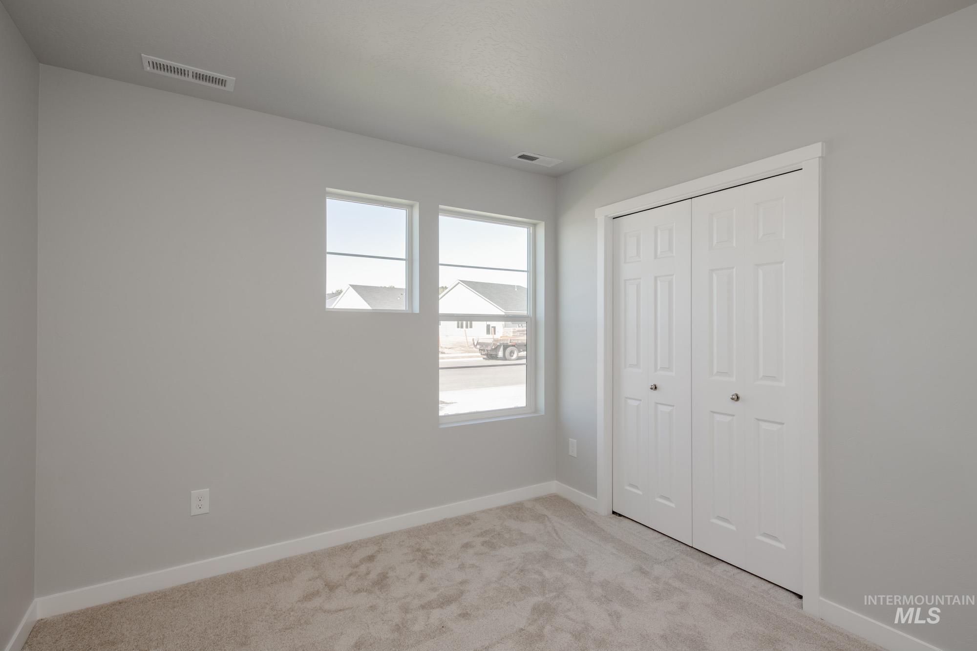 Unfurnished bedroom featuring light carpet and a closet