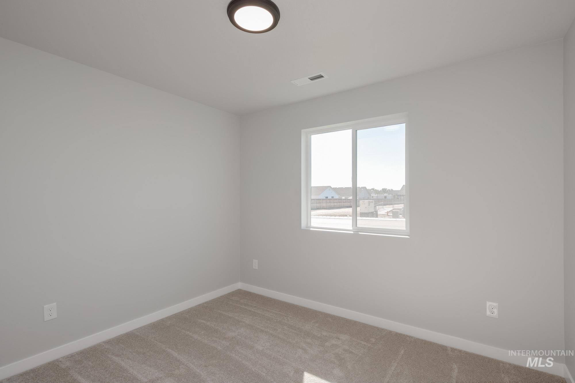 Spare room featuring carpet floors and baseboards