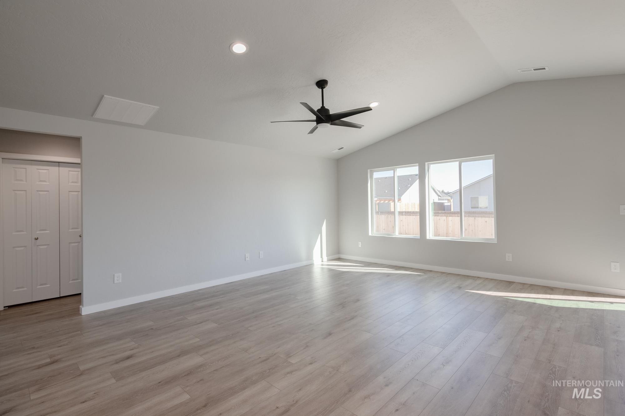Spare room featuring light wood-style flooring, lofted ceiling, recessed lighting, and ceiling fan