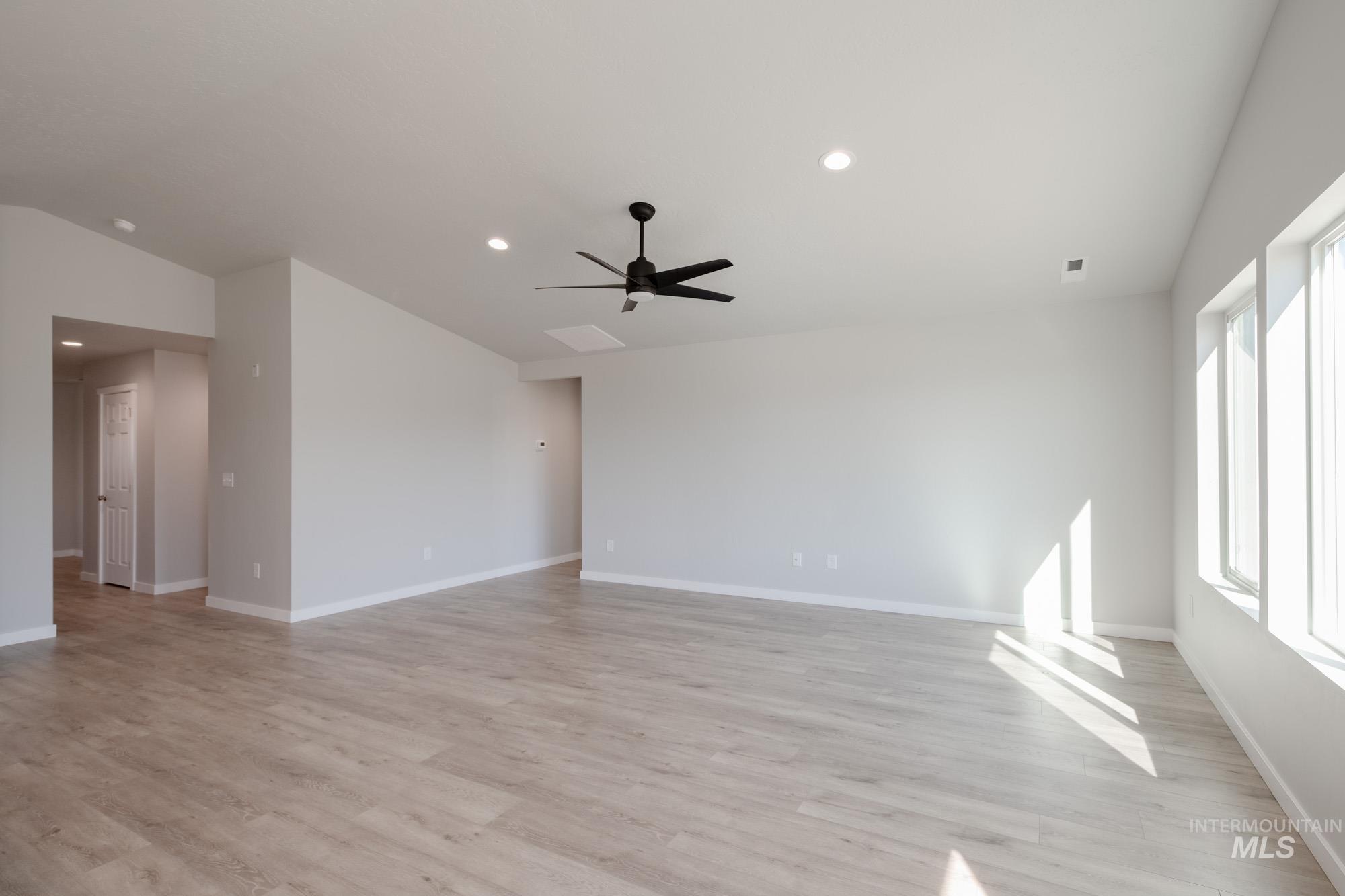 Spare room with light wood-style flooring, recessed lighting, ceiling fan, and vaulted ceiling