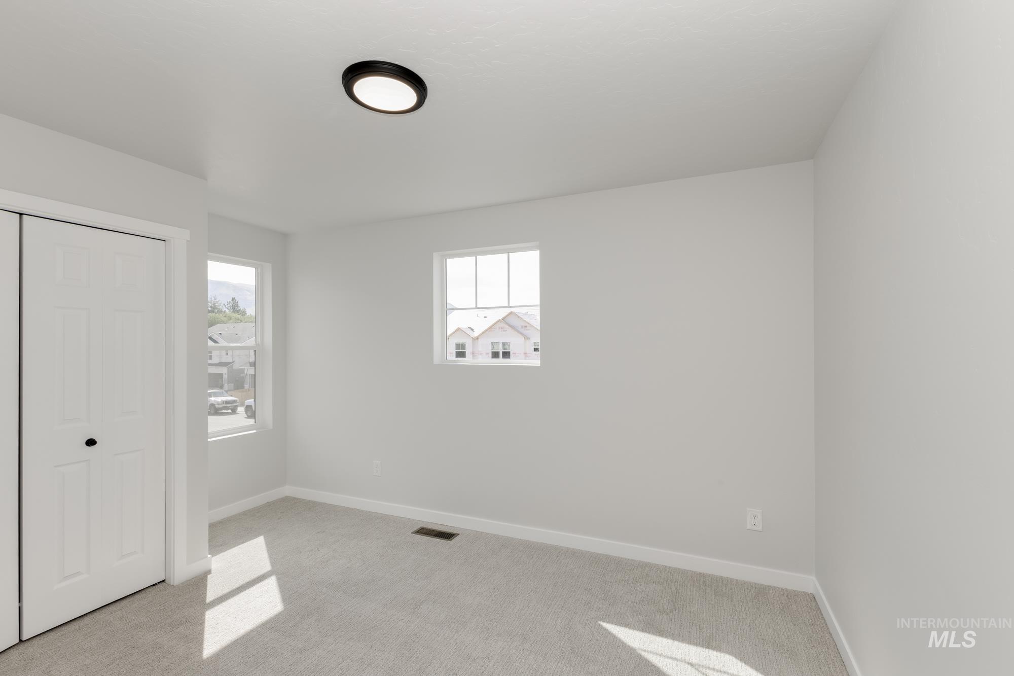 Unfurnished bedroom with light carpet and a closet