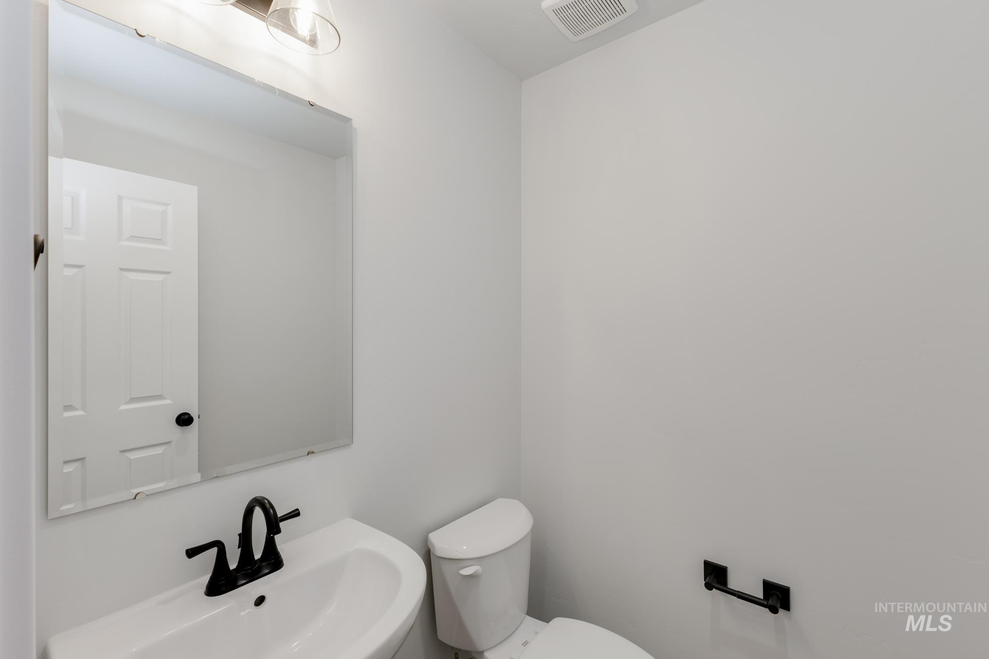 Half bathroom featuring toilet and a sink