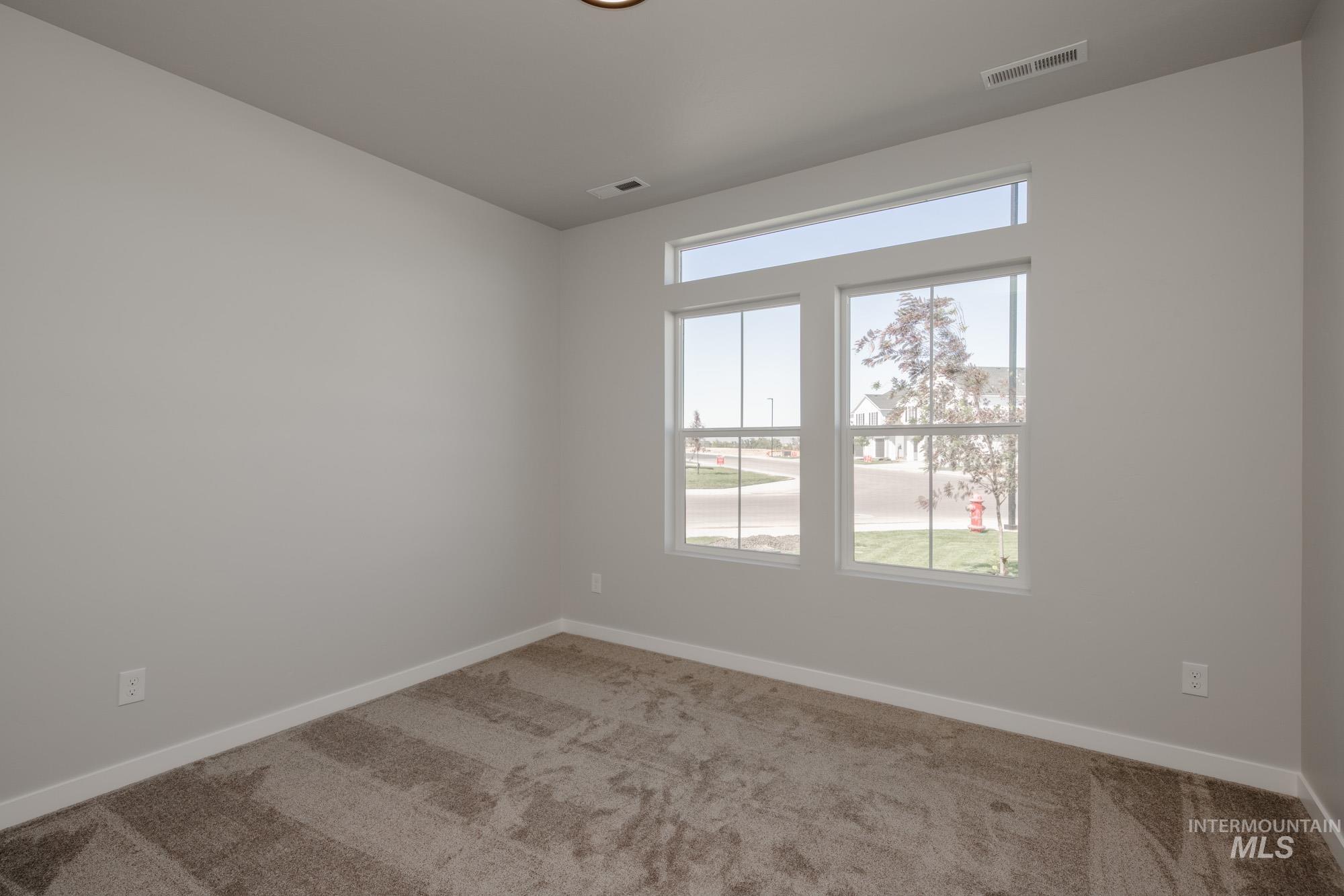 Carpeted empty room featuring baseboards