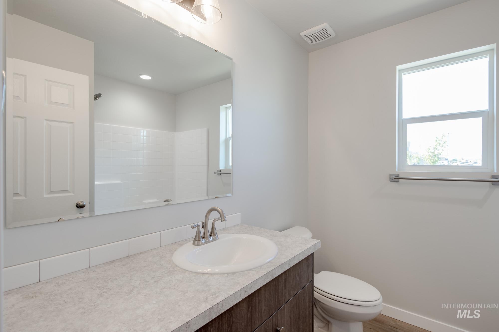 Bathroom with vanity, wood finished floors, and a shower