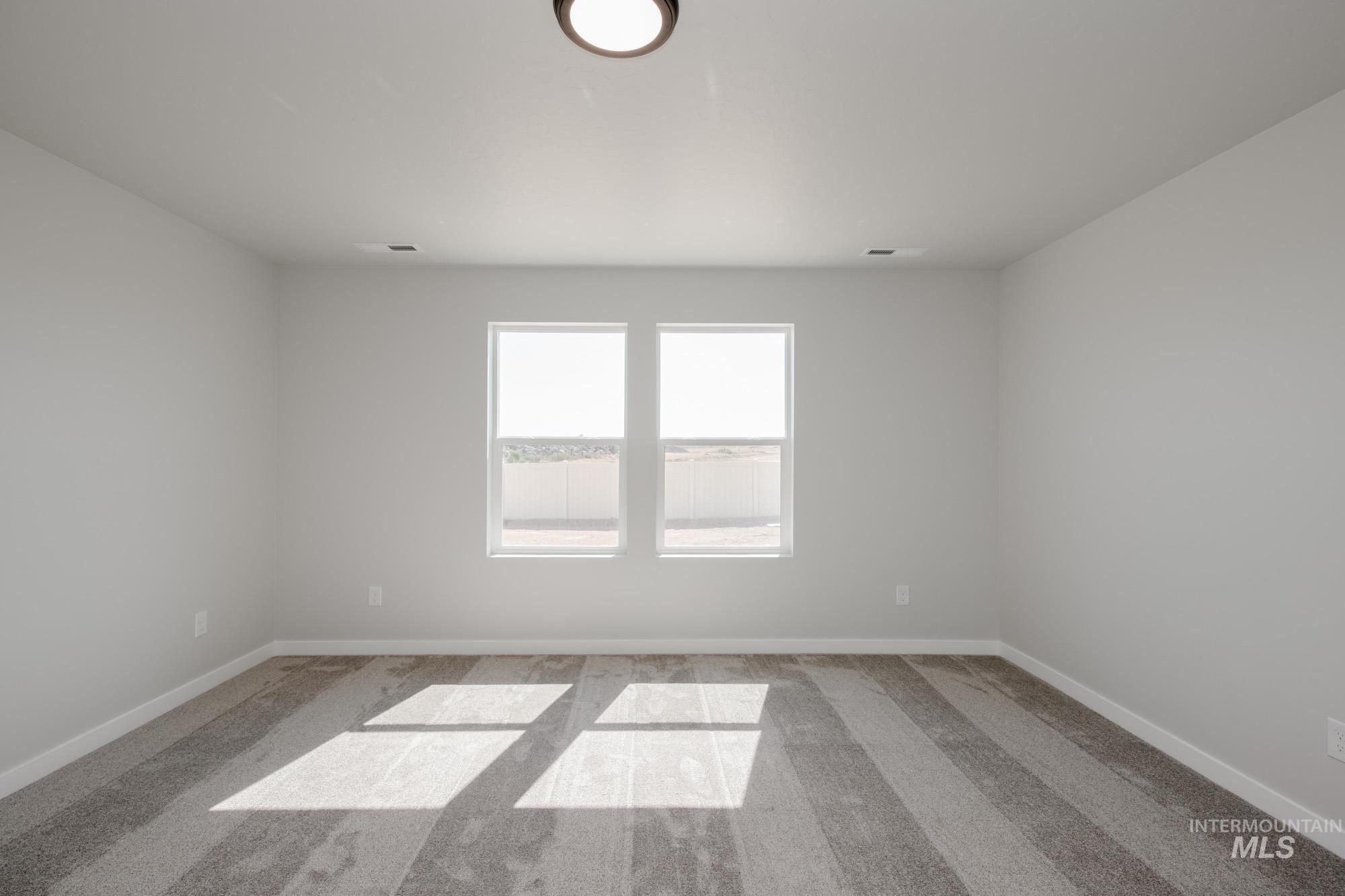 Empty room with light carpet and baseboards