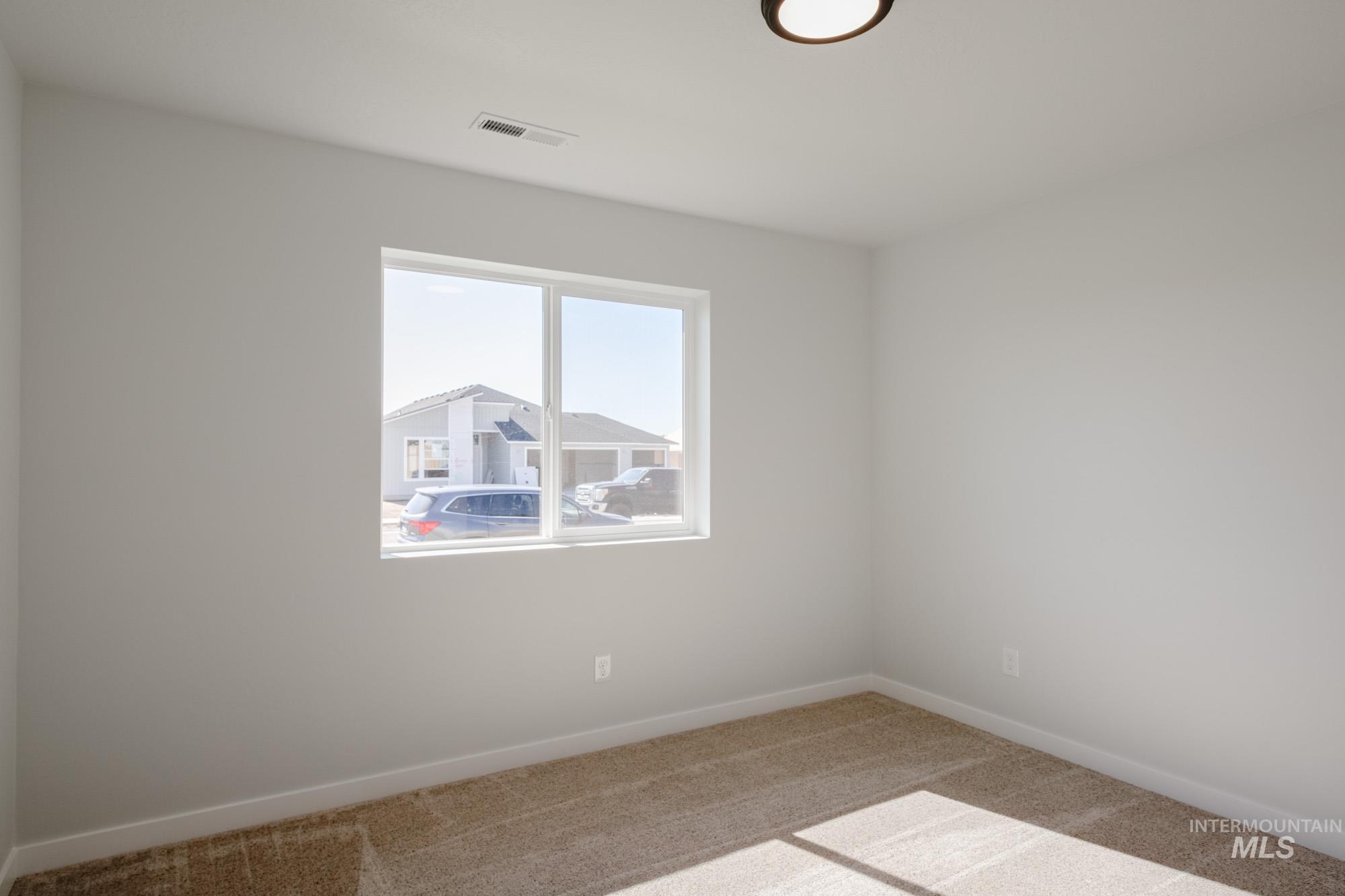 Carpeted spare room with baseboards
