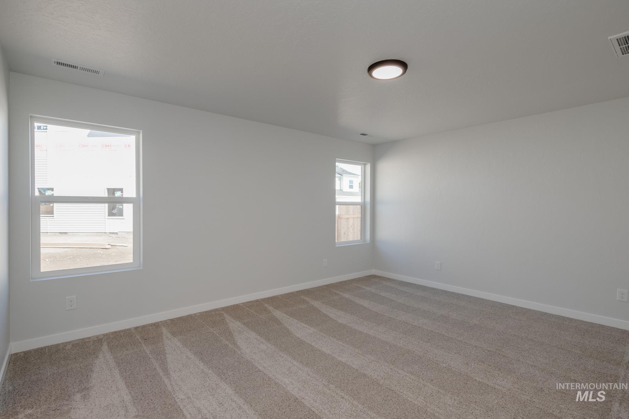 Carpeted spare room with baseboards