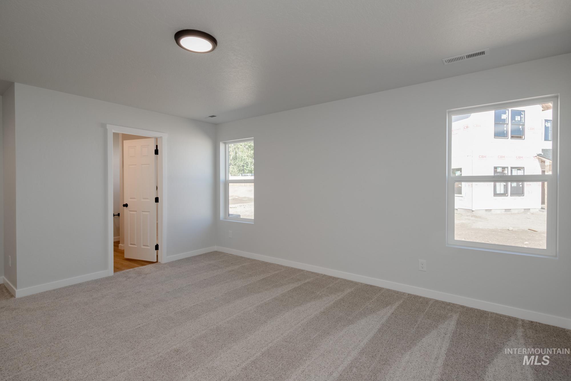 Empty room with light carpet and baseboards
