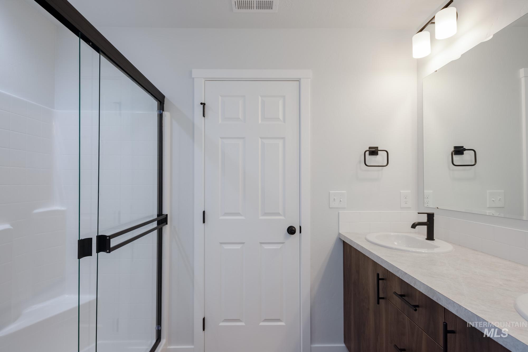 Full bath with a stall shower and double vanity