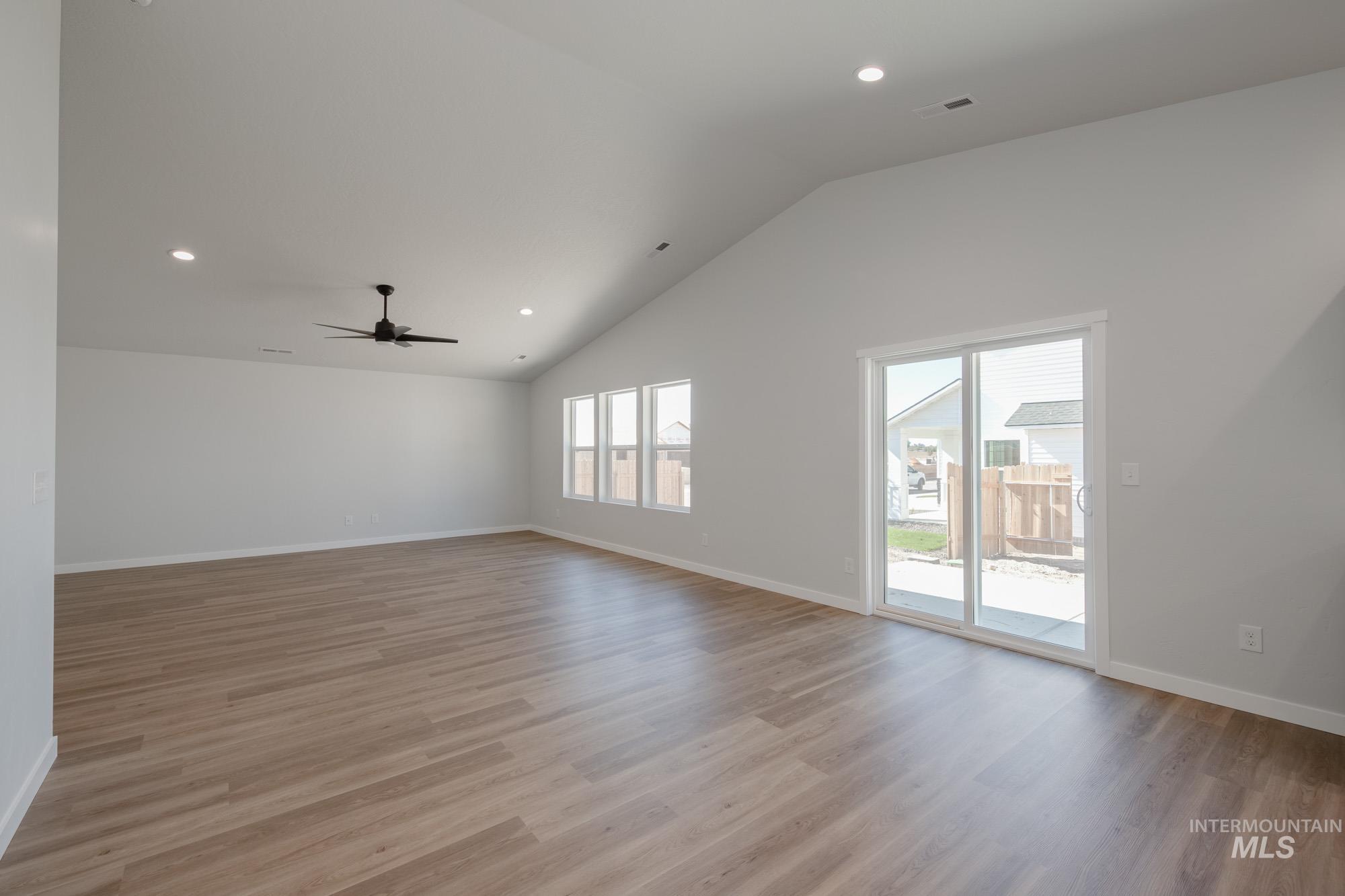 Spare room featuring recessed lighting, light wood-type flooring, a ceiling fan, and high vaulted ceiling