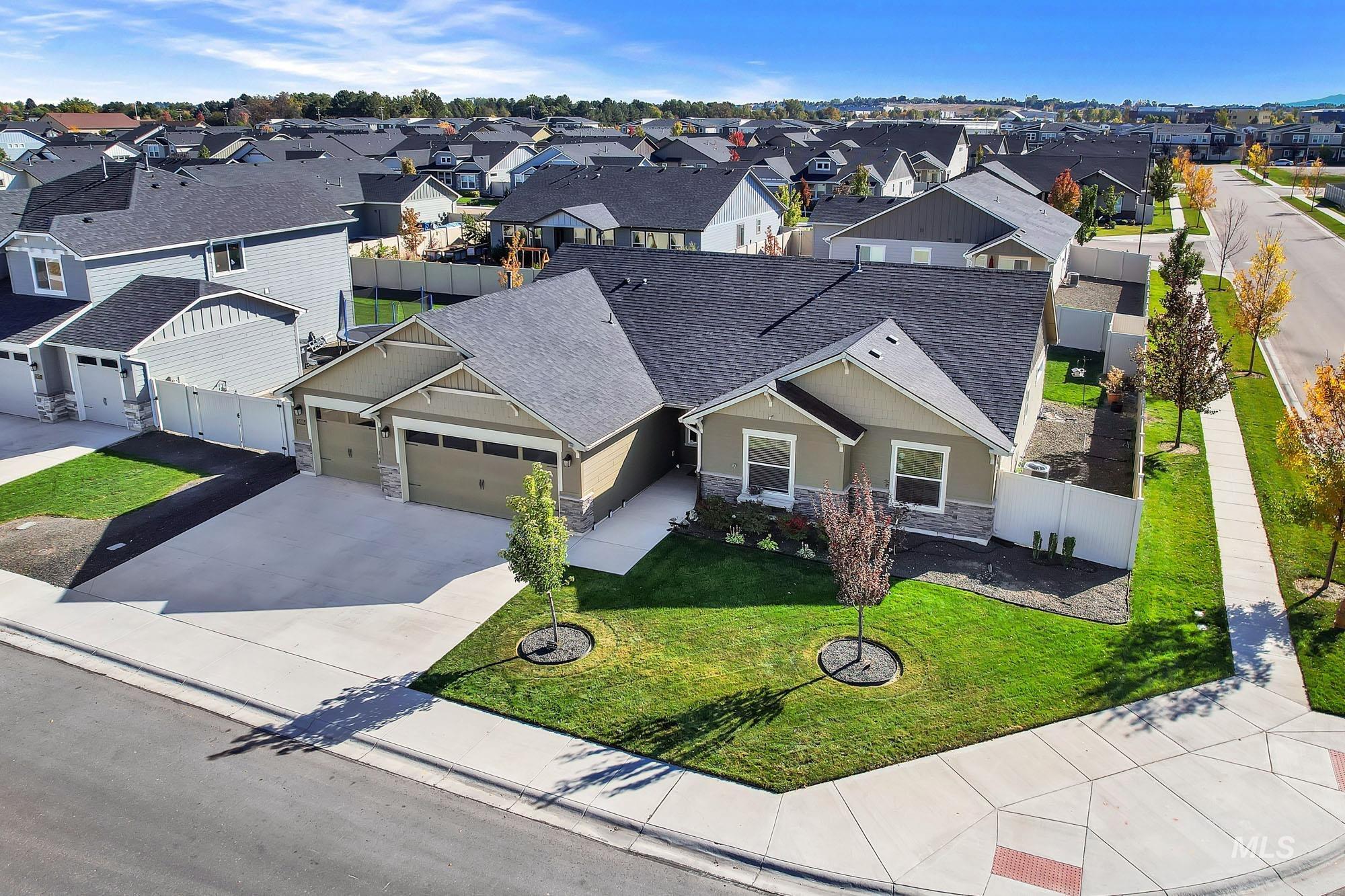 View of front of house featuring a shingled roof, stone siding, driveway, an attached garage, and a residential view
