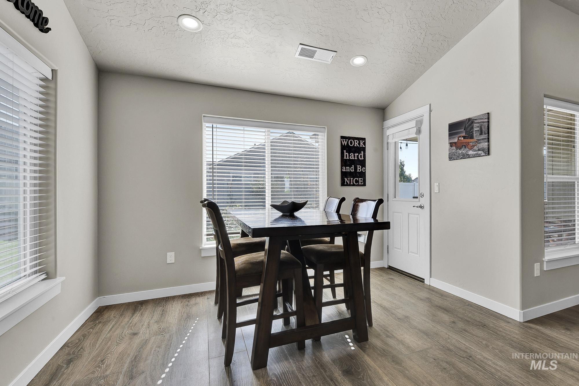Dining area featuring recessed lighting, wood finished floors, and a textured ceiling