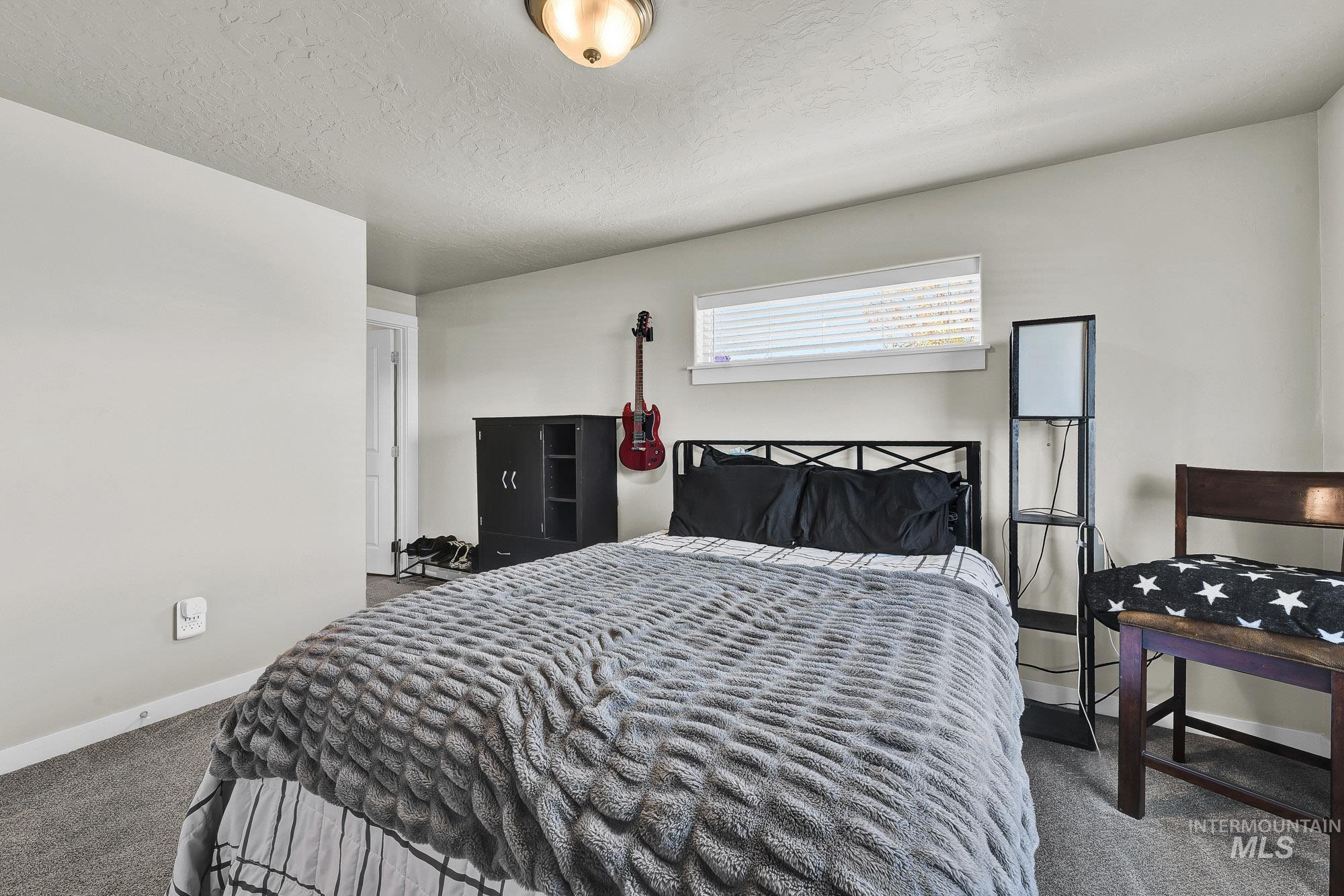 Bedroom featuring carpet and a textured ceiling