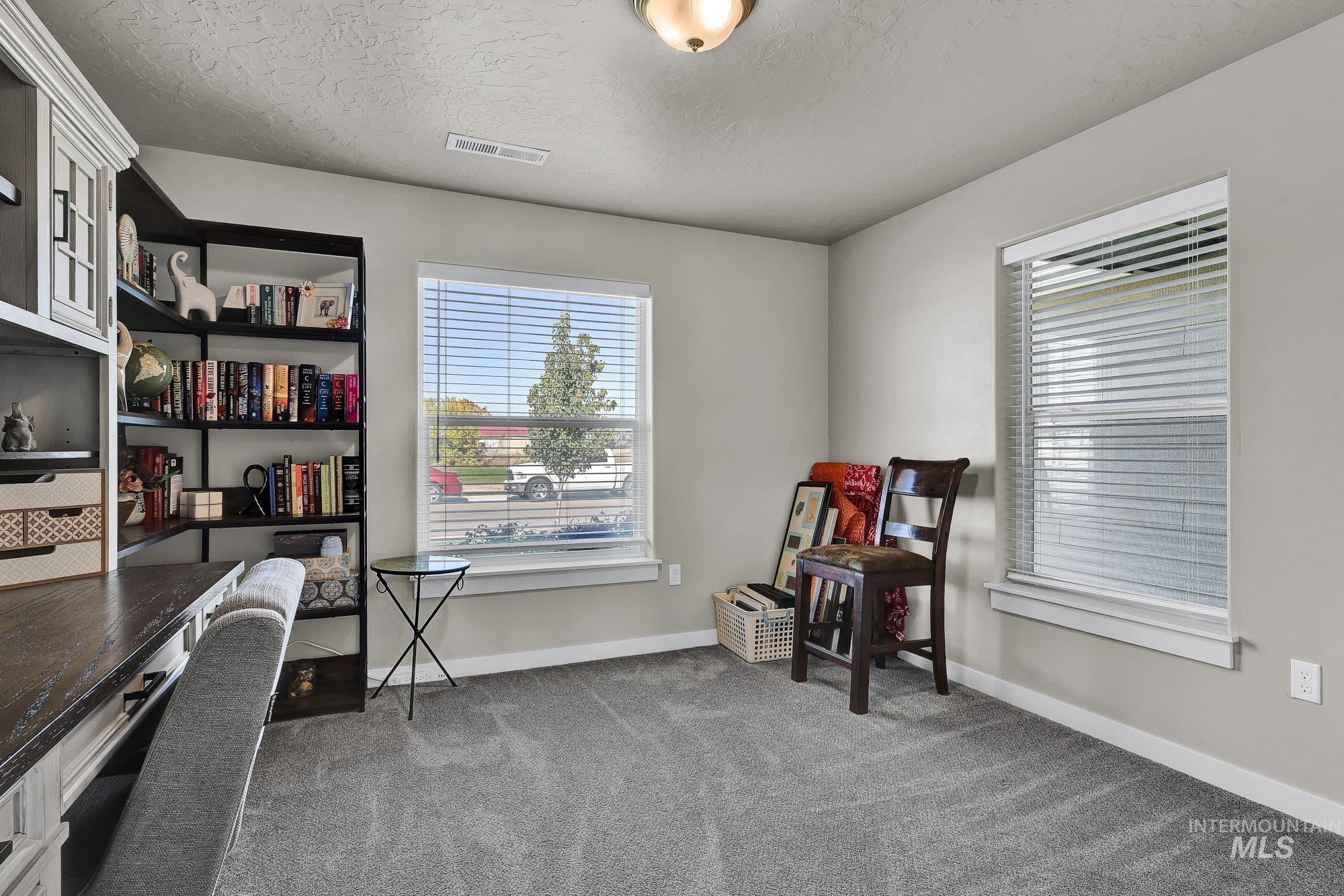 Office space featuring light colored carpet and a textured ceiling