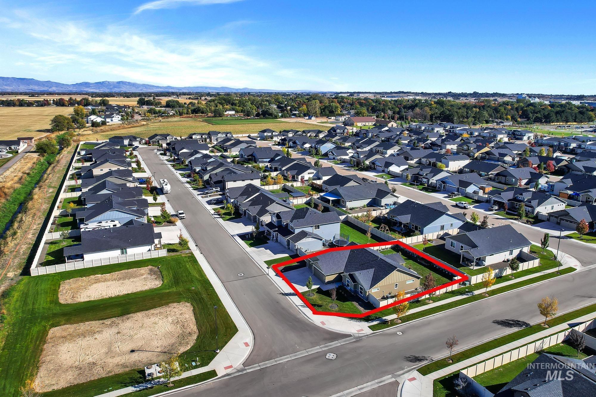 Aerial view of residential area featuring property boundaries highlighted and mountains