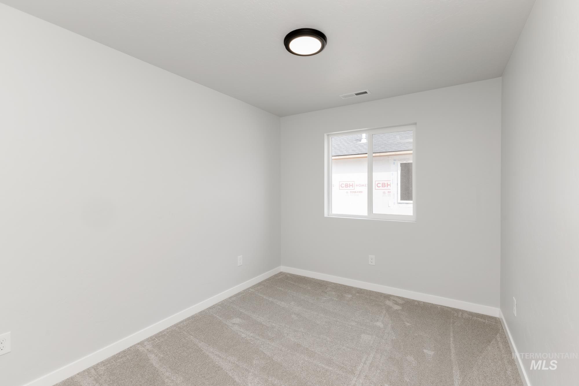 Carpeted spare room with baseboards
