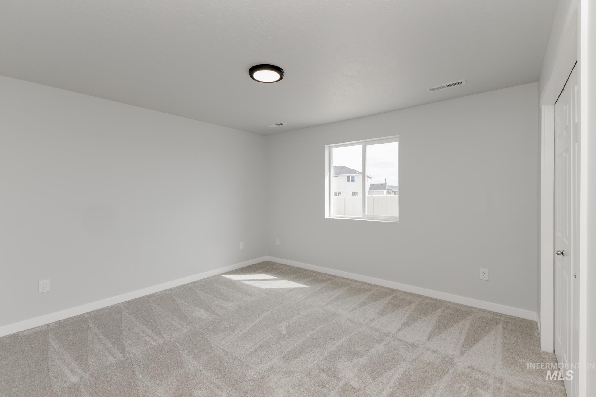 Unfurnished bedroom with light carpet and a closet