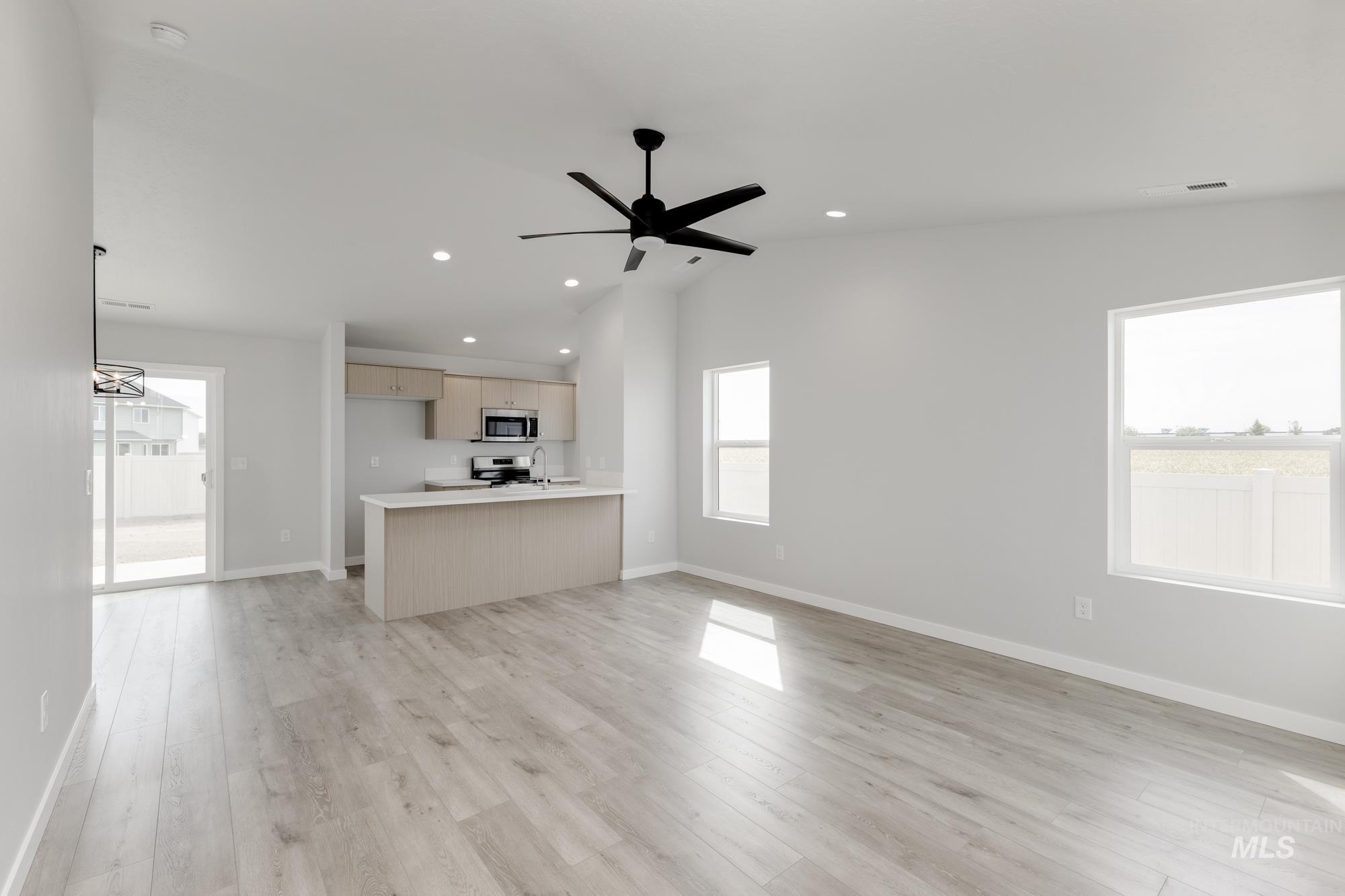 Unfurnished living room featuring plenty of natural light, light wood finished floors, ceiling fan, and recessed lighting