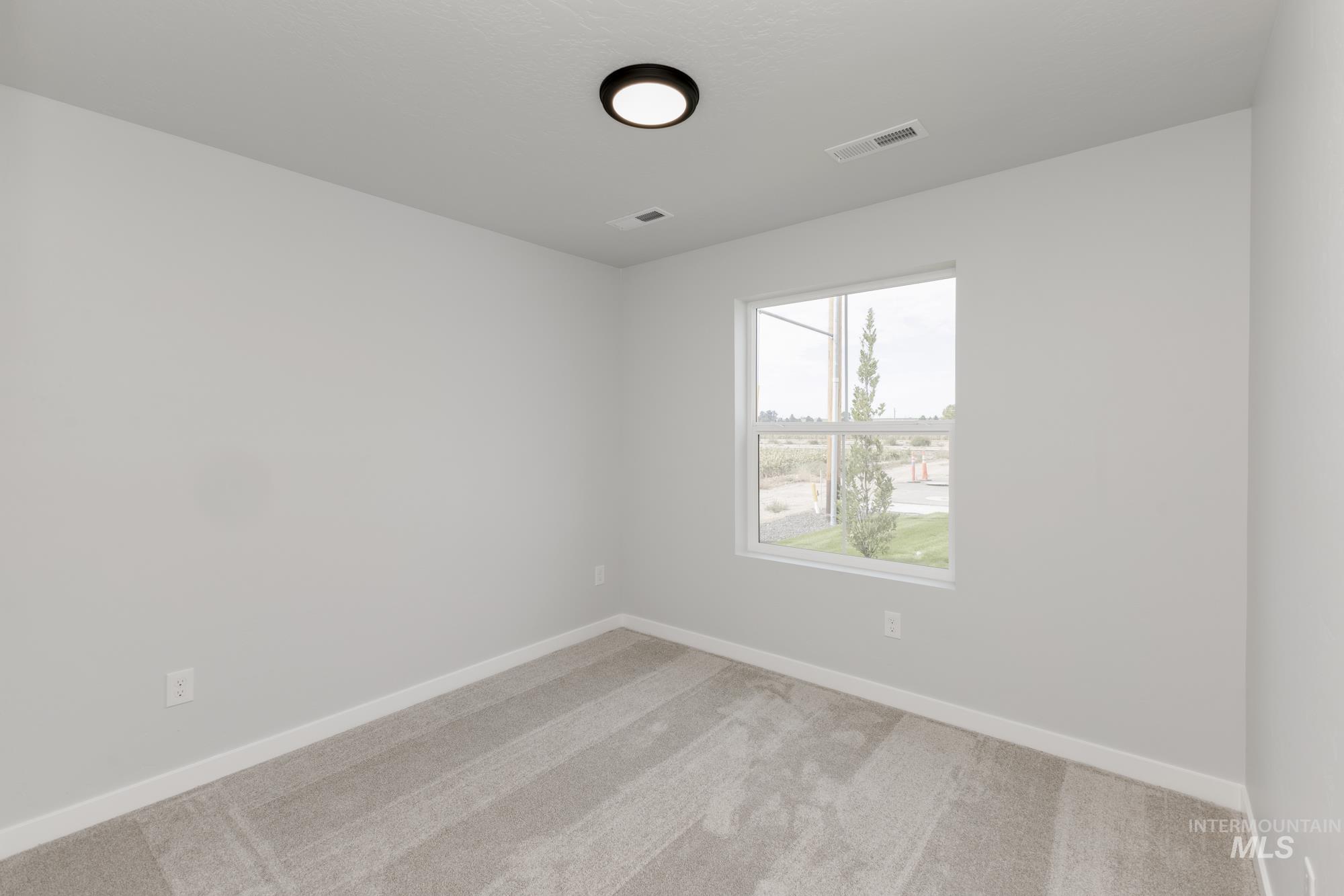 Empty room featuring carpet flooring and baseboards