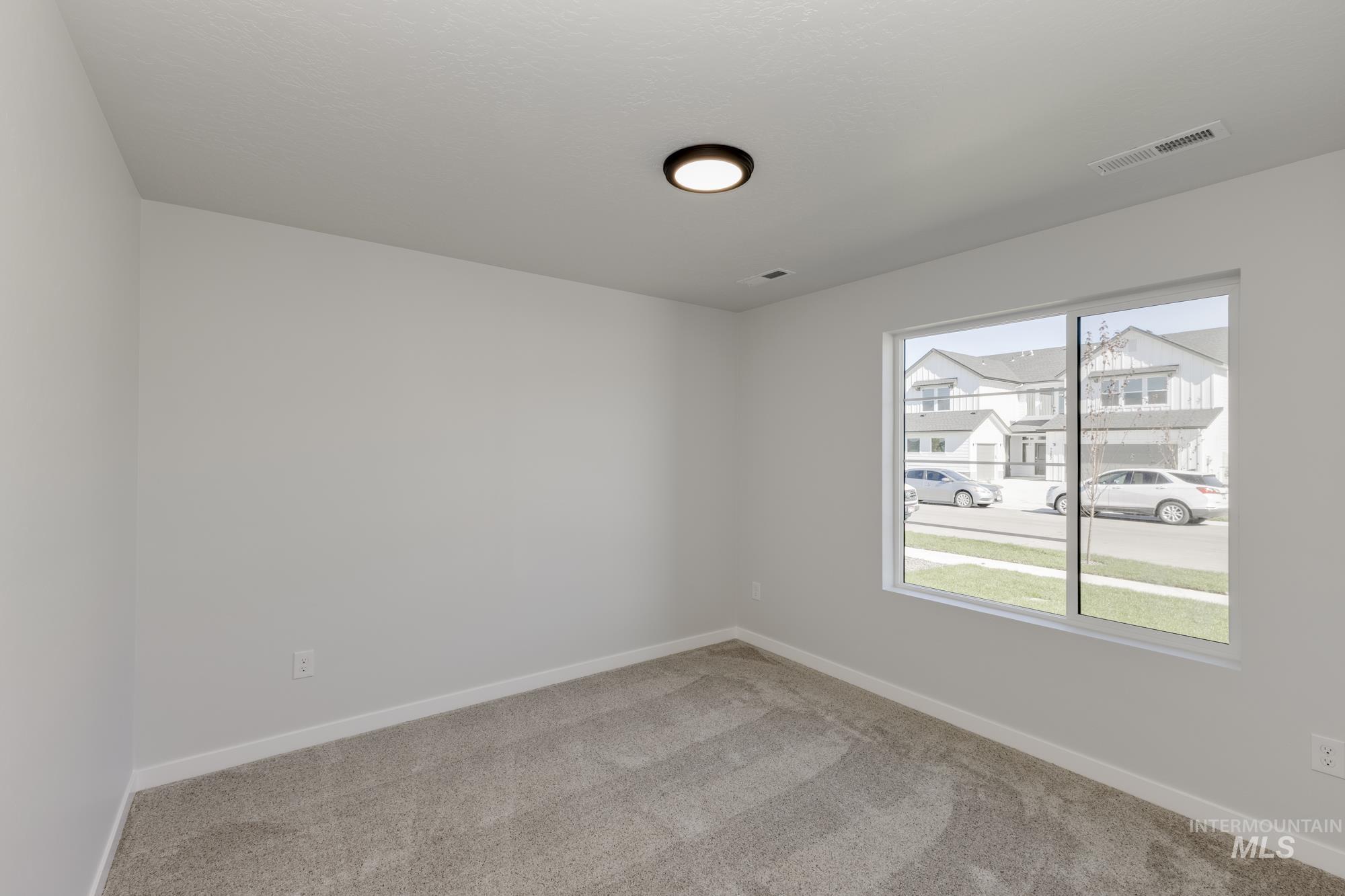 Empty room featuring light carpet and baseboards