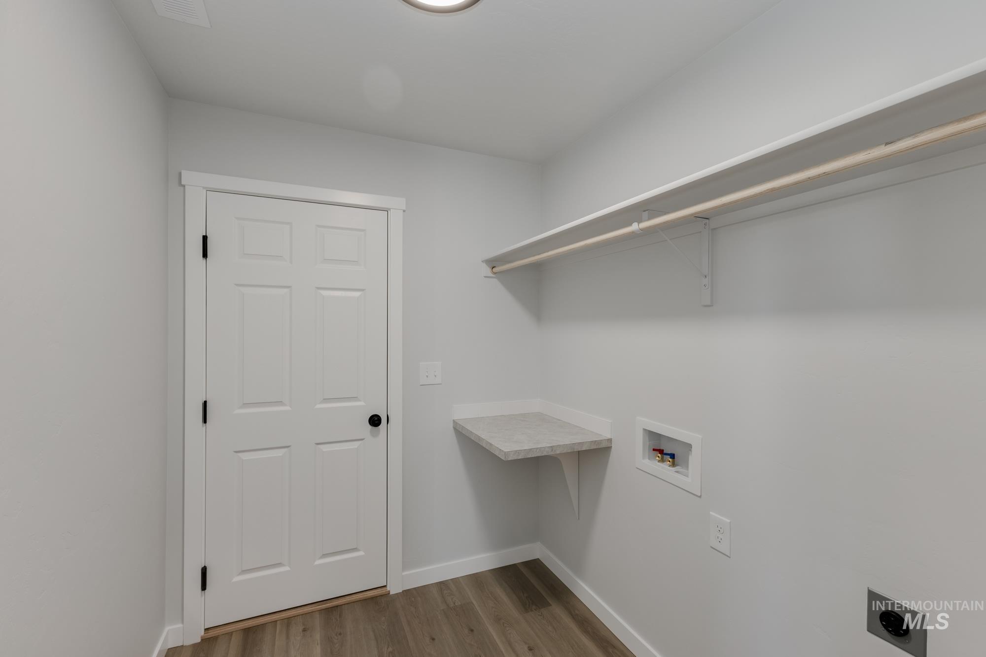 Laundry room with hookup for a washing machine, light wood-type flooring, and electric dryer hookup